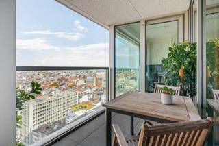 Welkom in de iconische Antwerp Tower, de maatstaf van modern wonen met een prachtig uitzicht over de stad. Dit exclusieve tweeslaapkamerappartement op de 17de verdieping biedt dan ook een unieke woonervaring. <br /><br />Doordat je op 17de verdieping leeft, woon je letterlijk boven het bruisende stadsleven. Winkels, cultuur, gastronomie en openbaar vervoer bevinden zich hier allemaal binnen handbereik. Vanuit het appartement stap je zo de De Keyserlei, de Meir of de Opera tegemoet. Tegelijkertijd geniet je, hoog boven de stad, van een uitzonderlijk gevoel van rust, privacy en ruimte. Een unieke woonplek die erin slaagt de dynamiek van Antwerpen, design, luxe en bovenal het uitzicht, te combineren tot een woonbeleving van een ander niveau. <br /><br />Via de centraal gelegen inkomhal, dewelke is voorzien van een toilet en een handige berging, heeft men toegang tot alle ruimtes van het appartement. De leefruimte beschikt over raampartijen die het levendige canvas van de stad weerspiegelen met aansluitend de goed uitgeruste open keuken. <br /><br />Verder zijn er nog twee slaapkamers die alle comfort en rust bieden en een badkamer met inloopdouche en wastafelmeubel.<br /><br />Het terras, ter bereiken vanuit de leefruimte en vanuit de slaapkamers, met uitzicht over de stad. <br /><br />Het comfort wordt alleen nog maar verhoogd door de aanwezigheid van een extra berging en een optioneel aan te kopen, ondergrondse parkeerplaats aan €50.000. (laadpaal wordt nog geïnstalleerd) <br /><br />EPC 58 = A