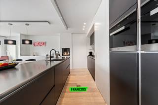 Dit uitzonderlijk ruim en luxueus appartement is gelegen in residentie Park Leopold II 1 te Wenduine op de eerste verdieping en op een rustige ligging net buiten het centrum. Dankzij de samenvoeging van twee appartementen geniet dit eigendom van een bijzonder royale bewoonbare oppervlakte van maar liefst 146 m². Bovendien werd voor de inrichting en afwerking samengewerkt met een architect, wat resulteert in een feilloos afgewerkt en modern geheel met een stijlvolle uitstraling.<br /><br />Bij het betreden van het appartement springt de hoogwaardige afwerking meteen in het oog. De ruime inkomhal, voorzien van praktische ingemaakte kasten, vormt de perfecte binnenkomer en biedt toegang tot de verschillende ruimtes van het appartement. Via een elegante deur bereikt men de leefruimte waar een organische overgang en het grote schuifraam zorgen voor een bijzonder open en lichtrijk gevoel.<br /><br />De woonkamer werd uiterst doordacht ingericht met een gezellige zithoek, een geïntegreerde bureauruimte en een centrale boekenkast die op subtiele wijze de scheiding vormt tussen de eetplaats en de leefruimte. De stijlvolle open keuken is uitgerust met alle moderne comfort en hoogwaardige toestellen. Eyecatcher van de ruimte is zonder twijfel de gezellige gashaard die extra sfeer creëert. Centraal in de keuken bevindt zich bovendien een praktische berging waar niet alleen extra opbergruimte voorzien werd, maar waar ook alle technische installaties van het appartement netjes gecentraliseerd zijn.<br /><br />Via de leefruimte bereikt men de eerste ruime slaapkamer, die beschikt over een ensuite badkamer met douche, lavabo en toilet. Aan de andere zijde van het appartement bevinden zich nog twee volwaardige slaapkamers, beide voorzien van ingemaakte kasten en met toegang tot het tweede terras van het appartement. Verder is er nog een tweede badkamer aanwezig, uitgerust met een inloopdouche en dubbele lavabo. In de inkomhal bevindt zich bovendien nog een apart gastentoilet.<br /><br />Het appartement beschikt over dubbele beglazing, individuele centrale verwarming op aardgas en conforme elektriciteit. Dankzij de gunstige EPC-score vormt dit appartement niet alleen een stijlvolle, maar ook energiezuinige woonoplossing.<br /><br />Ten slotte bevindt zich in de kelderverdieping ook een dubbele garage, verplicht aan te kopen voor 100.000 EUR. <br /><br />Kortom, een unieke kans voor wie op zoek is naar een luxueus afgewerkt appartement met royale volumes, veel lichtinval en een uitstekende ligging aan de Belgische kust. Ideaal als vaste woonplaats, tweede verblijf of investering. Plan nu uw bezoek in!<br /><br />