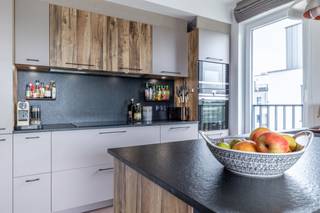 <p><strong>We Invest Sud-Luxembourg</strong> stelt u dit <strong>prachtige appartement van hoge kwaliteit</strong> voor, ideaal gelegen in het hart van <strong>Aarlen</strong>, op de 2e verdieping van een recent gebouw met lift (2019–2020 – Promotor Houyoux), vlak bij alle voorzieningen.</p>
<p>Bij binnenkomst wordt u verwelkomd in een <strong>ruime inkomhal met vestiaire</strong>, die leidt naar een lichtrijke leefruimte:<br />een <strong>Schmidt-keuken met centraal eiland</strong>, open naar een <strong>woonkamer met eiken parket</strong>, met directe toegang tot een <strong>overdekt terras van 8 m² op het zuiden</strong>.</p>
<p>Het slaapgedeelte omvat <strong>3 slaapkamers</strong>, waarvan één een <strong>ouderlijke suite met op maat gemaakte dressing en privébadkamer in massief hout</strong>. Een <strong>tweede badkamer met bad</strong>, een <strong>afzonderlijk toilet</strong>, en <strong>talrijke ingebouwde opbergmogelijkheden</strong> vervolledigen het geheel.</p>
<p>Daarnaast beschikt het pand over een <strong>privékelder</strong> en <strong>twee overdekte parkeerplaatsen</strong>.</p>
<p><strong>Technische kenmerken:</strong><br />EPC klasse <strong>A</strong>, verwarming op gas met gemeenschappelijke ketel, <strong>dubbele flux ventilatie</strong>, <strong>PVC driedubbele beglazing</strong>, <strong>elektrische rolluiken</strong>, maatmeubilair, privékelder.<br />Gebouw met <strong>lift</strong>, <strong>zonnepanelen</strong> en een <strong>regenwaterreservoir</strong>.</p>
<p><strong>Gemeenschappelijke kosten:</strong> ongeveer €200/maand – Syndicus: Serenity.</p>
<p>Een zeldzame kans die <strong>topligging</strong>, <strong>modern comfort</strong> en <strong>energiezuinigheid</strong> combineert!</p>
<p>Voor meer info of een bezoek: contacteer ons via +32 (0)63 33 00 69 – sud.luxembourg@weinvest.be</p>
