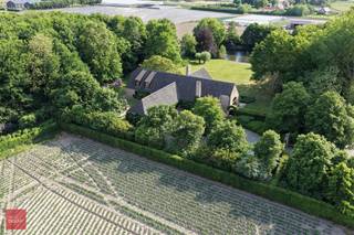 Prachtige eigendom met bos, prachtige tuin, vijver en ruim landhuis bestaande uit inkomhal, bureel, zeer ruime living met open haard, eetplaats, keuken met ontbijthoek en koelcel, wasplaats, kelders en een ruim overdekt zwembad (of hobbyruimte) met jacuzzi, verkleedruimte en douche. Ruime slaapkamer met badkamer en dressing op gelijkvloers en 2 ruime kamers (ev. 3) met badkamer op verdiep.  Garage met zolder (hobbyruimte), tuinberging, en ruime terrassen met zicht op landschapstuin met vijver.<br />Eventueel mogelijk ca. 4.700m² landbouwgrond bij te kopen.<br /><br /> 