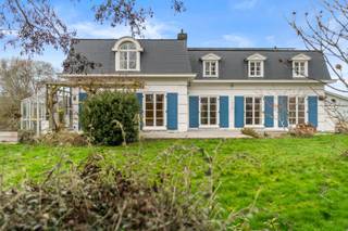 Op een uitzonderlijke locatie, op enkele minuten wandelen van het strand, verschuilt zich deze stijlvolle villa in een oase van groen en rust. Een eigendom waar ruimte, comfort en charme perfect samenkomen.<br /><br />De statige oprit verwelkomt u op dit prachtig perceel van 1.350 m² en zet meteen de toon. Binnenin wordt u ontvangen in een royale inkomhal met open trap, die leidt naar een lichtrijke leefruimte met warme uitstraling en gezellige haard. De grote glaspartijen creëren een naadloze verbinding met de zonnige tuin en laten het daglicht rijkelijk binnenstromen.<br /><br />De eetruimte sluit harmonieus aan en vormt samen met de aparte, volledig uitgeruste keuken het hart van de woning — ideaal voor wie houdt van tafelen en genieten. Op het gelijkvloers vindt u daarnaast een multifunctionele kamer die perfect dienst kan doen als bureau, speelkamer of extra slaapkamer. Een gastentoilet en technische ruimte vervolledigen dit niveau.<br /><br />Boven wachten vier volwaardige slaapkamers, een stijlvolle badkamer, een afzonderlijke douchekamer en een apart toilet. De indeling biedt optimaal comfort voor een gezin of voor wie graag gasten ontvangt. Extra bergruimte is voorzien op de zolder.<br /><br />Ook buiten ontbreekt het aan niets: een praktische tuinberging en een carport voor twee wagens zorgen voor extra comfort. De volledig omheinde tuin garandeert maximale privacy en vormt een ideale plek om in alle sereniteit te ontspannen.<br /><br />Deze eigendom biedt niet alleen een unieke ligging vlak bij zee, maar ook energiezuinig wonen dankzij zonnepanelen en een gunstig EPC B-label. De volledige kruipkelder verhoogt het praktische comfort.<br /><br />Een instapklare villa waar levenskwaliteit centraal staat — een zeldzame kans op een toplocatie aan de kust.<br /><br />