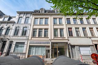 <strong>Dubbele handelswoning<br /></strong><br />Gelegen aan de Anselmostraat bevindt zich deze riante <strong>dubbelwoonst </strong>met een gevelbreedte van maar liefst 10m.<br />De twee woningen liggen in het hart van de <strong>Harmoniewijk</strong>: rustig gelegen en toch makkelijk bereikbaar met een vlotte verbinding in en uit de binnenstad. Hier woon je tussen de statige herenhuizen, op wandelafstand van het Zuid en achter het vernieuwde Justitiepaleis. De straat zelf wordt vernieuwd en is verrassend rustig voor haar centrale ligging.<br /><br />Het gebouw bestaat uit twee naast elkaar gelegen <strong>handelshuizen</strong>, elk met een eigen kadastrale aanduiding. De panden zijn destijds feitelijk samengevoegd tot één functioneel geheel, maar kunnen weer opgesplitst worden <strong>tot twee woningen</strong>. Samen bieden ze een totaaloppverlakte van ca. 570 m².<br />Op het gelijkvloers bevinden zich twee handelsruimtes met aparte toegang, elk uitgerust met keuken en sanitair. Deze kunnen blijven functioneren als <strong>commerciële ruimtes </strong>of geïntegreerd worden in een toekomstige woonfunctie. Daarboven is het pand verdeeld over meerdere verdiepingen met woonfuncties: twee appartementen over de volledige breedte, een tussenverdieping met extra kamer, een mansarde met vier bijkomende kamers en een zolderruimte bovenaan.<br />De kelders zijn droog, ruim en beschikken over voldoende hoogte.<br />In 2024 werd het dak nog volledig vernieuwd en geïsoleerd.<br /><br />De twee woningen bieden een interessant <strong>ontwikkelingspotentieel</strong> tot het realiseren van twee ruime stadswoningen met commerciële invulling op het gelijkvloers.