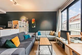Voor meer info en foto’s, surf naar www.swevers.be – Dit instapklare appartement op de derde verdieping geniet van een centrale ligging in de Diestsestraat in Leuven. U woont hier midden in de winkelstraat, op wandelafstand van het station en het stadscentrum. Winkels, restaurants, scholen en ontspanningsmogelijkheden bevinden zich in de nabije omgeving, terwijl de aansluiting op de snelwegen vlot bereikbaar is. Het appartement maakt deel uit van een kleinschalig gebouw en biedt een praktische en functionele indeling op een bewoonbare oppervlakte van 49 m². Dankzij de moderne afwerking kunt u zonder grote renovatiewerken meteen verhuizen of verhuren. De lichtrijke leefruimte van ongeveer 20 m² vormt het hart van het appartement. Grote ramen zorgen voor een aangename lichtinval en creëren een open sfeer. Aansluitend bevindt zich de compacte, praktisch ingerichte keuken, waar u tijdens het koken contact behoudt met de leefruimte. Een aparte berging biedt extra plaats voor voorraad en huishoudelijke spullen. De badkamer is centraal gelegen en uitgerust met lavabo, toilet en douche. Achteraan bevindt zich de slaapkamer van circa 12 m², rustig gelegen weg van de straatzijde. Hier is voldoende ruimte voor een dubbel bed en kastruimte. Een absolute meerwaarde is het ruime terras aan de achterzijde. Deze aangename buitenruimte biedt plaats voor een tafel, stoelen en planten, waardoor u ook in het centrum van Leuven kunt genieten van een rustig moment in openlucht. Dankzij de combinatie van een uitstekende ligging, een praktische indeling, een lichtrijke leefruimte, een aparte berging en een gezellig terras vormt dit appartement een interessante opportuniteit voor zowel eigen bewoning als investering. Voor meer informatie, bel 011 255 155. Bron bewoonbare oppervlakte: EPC – verslag.
