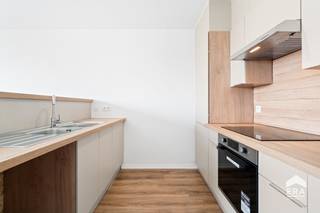 [[ DIT PAND NEEMT DEEL AAN DE ERA OPEN HUIZEN DAG OP 19/9 VAN 17:30 TOT 18:30 ]]
<h3>Licht en centraal gelegen appartement met twee terrassen</h3>

<p>Op zoek naar een appartement met een <strong>uitstekende ligging en een prachtig uitzicht</strong>? Dit aangename appartement op de <strong>5de verdieping</strong>, gelegen <strong>recht tegenover het station</strong>, combineert comfort met een bijzonder centrale ligging.</p>

<p>Het appartement beschikt over een aangename leefruimte met een <strong>nieuwe open keuken</strong>, ideaal voor wie houdt van een moderne en open woonbeleving. Dankzij de ligging op de hogere verdieping geniet u bovendien van een mooie lichtinval en een aangenaam uitzicht.</p>

<p>Er zijn <strong>twee slaapkamers</strong>, waardoor het appartement zowel geschikt is voor een koppel, een klein gezin als voor wie een extra kamer wenst als bureau of hobbyruimte.</p>

<p>Een grote troef zijn de <strong>twee terrassen</strong>: zowel vooraan als achteraan beschikt u over een buitenruimte waar u op elk moment van de dag heerlijk kunt genieten van het buitenleven.</p>

<p>Ook de locatie is bijzonder praktisch. <strong>Openbaar vervoer, scholen, winkelcentra en de sporthal</strong> bevinden zich allemaal op wandelafstand. Daarnaast is er <strong>parkeergelegenheid</strong> in de omgeving.</p>

<p><strong>Troeven:</strong></p>

<ul><li>Gelegen op de 5de verdieping</li><li>Recht tegenover het station</li><li>2 slaapkamers</li><li>Nieuwe open keuken</li><li>Terras vooraan én achteraan</li><li>Veel voorzieningen op wandelafstand</li><li>Nabij openbaar vervoer, scholen en winkelcentra</li><li>Sporthal in de onmiddellijke omgeving</li><li>Parkeergelegenheid</li></ul>

<p><strong>Een ideale combinatie van centrale ligging, comfort en buitenruimte. Een appartement dat zeker een bezoek waard is!</strong></p>
