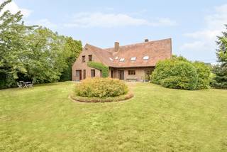 Op een prachtig perceel van maar liefst 19are 58ca bevindt zich deze landelijke en energiezuinige villa met een indrukwekkende bewoonbare oppervlakte van 469 m². Deze stijlvolle woning werd in 1985 gebouwd met hoogwaardige en duurzame materialen die vandaag nog steeds getuigen van vakmanschap en kwaliteit. De villa is gelegen op slechts 3 minuten van het centrum van Herk-de-Stad.<br /><br />Doorheen de volledige woning werd gekozen voor authentieke Franse Bourgondische natuursteen, een tijdloos materiaal en de ideale warmtegeleider voor de aanwezige vloerverwarming. De ramen zijn uitgevoerd in duurzaam afzelia hout, gekend om zijn uitzonderlijke levensduur en elegante afwerking. Ook in de badkamer werd niet bespaard op kwaliteit, met de toepassing van stijlvol marmer dat zorgt voor een luxueuze toets. De keuze voor hoogwaardige materialen vormt een tijdloze basis die zich leent tot uiteenlopende interieurstijlen, van modern en klassiek tot landelijk.<br /><br />Een van de absolute troeven van deze villa is de doordachte architectuur, waarbij de volledige woning werd georiënteerd naar de zonnige, zuidwestelijk gerichte tuin. Dankzij deze indeling genieten vrijwel alle leefruimtes van een prachtig uitzicht op het groen en een maximale lichtinval gedurende de dag. <br /><br />Gelijkvloers<br /><br />Via de ruime inkomhal met apart gastentoilet betreedt u deze uitzonderlijke woning. Op het gelijkvloers vindt u een veelzijdige bureauruimte, die zich eveneens perfect leent als slaapkamer, een lichtrijke woon- en eetkamer en een ruime leefkeuken met voldoende plaats voor een royale eettafel. Aansluitend bevindt zich een sas dat toegang biedt tot de praktische achterliggende ruimtes, waaronder een aparte wasruimte, een hobbykamer met rechtstreekse toegang tot de tuin, een ruime voorraadkamer/berging, een extra toilet en een grote badkamer. Als extra troef beschikt de woning over een ruime dubbele inpandige garage, die zowel rechtstreeks vanuit de traphal als via het sas achteraan de woning toegankelijk is.<br /><br />Eerste verdieping<br /><br />De ruime nachthal geeft toegang tot vijf volwaardige slaapkamers en een zeer ruime badkamer en meerdere berguimtes. Eén van de kamers werd momenteel ingericht als zitruimte, maar biedt alle mogelijkheden om omgevormd te worden tot een prachtige mastersuite met dressing. Via een vaste trap bereikt u bovendien de zolderverdieping, waar nog tal van uitbreidingsmogelijkheden aanwezig zijn.<br /><br />Kelder<br /><br />De woning is volledig onderkelderd met kruipkelder enerzijds en anderzijds een ruime volwaardige kelderverdieping met een technische ruimte voor de verwarmingsinstallatie en nutsvoorzieningen, aangevuld met meerdere praktische bergruimtes. <br /><br />Tuin en buitenomgeving<br /><br />Buiten geniet u van een prachtig aangelegde, zuidwestelijk georiënteerde tuin met een aangenaam deels overdekt terras. Achteraan grenst het perceel aan agrarisch gebied, wat zorgt voor blijvende groene vergezichten, maximale privacy en een uitzonderlijk gevoel van ruimte.<br /><br />Deze uitzonderlijke eigendom combineert hoogwaardige materialen, een doordachte indeling, energiezuinig wooncomfort en een unieke groene ligging. Dankzij de veelzijdige opzet is ze perfect geschikt als kangoeroewoning, ruime ééngezinswoning of een woning met praktijkruimte.
