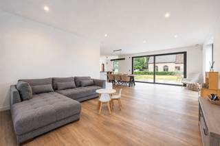 <p><strong>Hoogwaardig afgewerkte, recente en vrijstaande woning met o.a. 3 slaapkamers (mogelijkheid tot 4 of 5) en bijgebouw met tal van mogelijkheden op perceel van 1.112m² in Tielen. EPC: label A (61 kWh/m²). Elektriciteit conform.</strong></p>
<p><strong>Ligging:</strong> Centraal gelegen dicht bij het centrum van Tielen met een vlotte verbinding naar de omliggende gemeenten en E34.</p>
<p><strong>Indeling: 0:</strong> Inkomhal, apart toilet, bureau, open keuken, leefruimte, hal, wasplaats/berging <strong>+1:</strong> nachthal, slaapkamer 1 met dressing, slaapkamer 2, slaapkamer 3, dressing, badkamer, apart toilet <strong>+2:</strong> zolderverdieping <strong>buiten:</strong> terras, tuin, bijgebouw.</p>
<p><strong>Omschrijving:</strong></p>
<p>U betreedt deze vrijstaande woning via de inkomhal met apart toilet en trap naar de eerste verdieping. Vooraan bevindt zich de aparte bureauruimte die voorzien is van ingemaakte kasten en mogelijk biedt tot het ontvangen van klanten. Deze is toegankelijk via de inkomhal of via de keuken. De ruime leefruimte en open keuken geniet van veel natuurlijk lichtinval door de grote raampartijen die uitgeven op het terras en de tuin. Deze ramen zijn voorzien van zonwerende screens.</p>
<p>De hoogwaardige keuken is volledig uitgerust met koelkast, inductie kookplaat, ingebouwde dampkap, ingebouwde koffiemachine, combi-(stoom)oven, dubbele spoelbak, riant keukeneiland en uitzonderlijk veel kastruimte. Aansluitend bevindt zich de hal met veel ingemaakte kasten die toegang biedt naar de wasplaats/berging en naar de tuin.</p>
<p>Op de eerste verdieping bevindt zich de nachthal met apart toilet en de 3 slaapkamers, waarvan 1 met aansluitend een dressing. De 2 andere slaapkamers zijn ook voorzien van een gemeenschappelijke dressing die toegankelijk is via de nachthal. De slaapkamers zijn allemaal uitgerust met vliegenramen en verduisterende screens. De badkamer is uitgerust met inloopdouche, ligbad, dubbele wastafel en voldoende kastruimte.</p>
<p>De ruime zolderverdieping biedt tal van mogelijkheden en kan volledig worden ingericht volgens de wensen van de nieuwe eigenaar. Deze veelzijdige ruimte vormt een ideale basis voor het creëren van 1 of meerdere slaapkamers, een hobbyruimte, ontspanningsruimte, speelkamer… Er is ook nog een aparte technische berging aanwezig. De woning is energiezuinig o.a. door de aanwezigheid van ventilatiesysteem type D, 18 zonnepanelen en vloerverwarming.</p>
<p>Achteraan op het perceel bevindt zich een bijgebouw (140m²) met een brede waaier aan mogelijkheden, dat momenteel dienstdoet als garage. Het gebouw is op te frissen en bestaat uit een ruime kelder en een gelijkvloers met keuken, badkamer en apart toilet. Op de eerste verdieping bevinden zich nog 2 ruime kamers en een apart toilet.</p>
<p><strong>Bijzonderheden: </strong>aparte bureauruimte –<strong> </strong>ruime zolderverdieping – 18 zonnepanelen – ventilatie type D – ruime tuin – ruim bijgebouw</p>
<p><em>Bijzondere informatieplicht: in aanvraag</em></p>