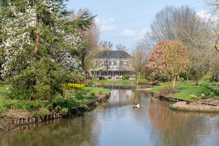 <p>Verscholen in het groen en omringd door grote variëteit van bomen, zeldzame struiken en strak aangelegde hagen, ligt deze karaktervolle villa die rust, privacy en elegantie moeiteloos combineert. Bij aankomst valt direct de charmante oprijlaan op, geflankeerd door perfect gesnoeide hagen die leiden naar de statige entree van de woning.</p>
<p>De architectuur straalt klasse uit: een tijdloze gevel met symmetrische raampartijen, sfeervolle luiken en een centrale voordeur die uitnodigt tot binnenkomen. <br />Statige entree met dubbele trap leidt via een glazen deur naar de leefruimte. De linkervleugel omvat een klassieke leefkeuken met eiland en afgewerkt met natuursteen. Het Godin kookfornuis vormt het pronkstuk. <br />De rechtervleugel omvat een gezellig salon rondom een authentieke haard. Het bureau is tevens toegankelijk via de inkomhal. <br />In de tuinkamer is het heerlijk vertoeven bij de eerste lentezon, een kostbare verlengenis van de woonkamer. Aan de achterzijde opent de volledige woning zich naar een prachtig aangelegde tuin, waar grote raampartijen zorgen voor een optimale verbinding tussen binnen en buiten. <br />De verdieping herbergt drie slaapkamers dewelke zijn verbonden via een lichte en comfortabele overloop. De hoofdslaapkamer met dressing heeft ensuite een luxueuze badkamer met wastafel, ligbad, inloopdouche en toilet. De overige twee slaapkamers beschikken ook telkens over een eigen badkamer.</p>
<p>De botanische tuin is zonder twijfel een absolute blikvanger. Een oase van rust waar elk seizoen tot zijn recht komt. Aan de achterzijde bevindt zich tevens een ruim Zuid-georiënteerd terras met zicht op een charmante binnenplaats, wat bijdraagt aan de serene en exclusieve sfeer van het geheel.</p>
<p><strong>Kenmerken:</strong></p>
<ul>
<li>Vrijstaande villa met klassieke uitstraling</li>
<li>Botanische parktuin</li>
<li>Veel privacy dankzij haagstructuren en een grote variëteit van bomen</li>
<li>Grote raampartijen met uitzicht op de tuin</li>
<li>Sfeervolle binnenplaats</li>
<li>Oprit en verzorgde entree</li>
</ul>
<p>Een unieke woning voor wie op zoek is naar ruimte, rust en een hoogwaardige leefomgeving met een uitgesproken karakter.</p>