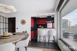 Welkom in residentie Willem de Brouwer. Op de achtste verdieping van dit goed onderhouden gebouw bevindt zich dit appartement, gelegen aan een gemeenschappelijke gang met slechts vier andere wooneenheden.<br />U betreedt het appartement via de inkomhal, die beschikt over praktische opbergruimte/wasplaats en ruimte voor een vestiaire. Via een moderne zwart stalendeur komt u in de lichtrijke woonkamer, waar u geniet van aangename namiddagzon. De mooie parketvloer biedt voldoende plaats voor een eethoek, salon en bureauruimte.<br />De ingesloten keuken is uitgerust met een combi-oven, vaatwasser, inductiekookplaat en lavabo. Daarnaast beschikt de leefruimte over een ingebouwde sierhaard, wat bijdraagt aan de gezellige sfeer.<br />De nachthal geeft toegang tot een privatief toilet en een extra opbergkast. Van hieruit bereikt u de ruime slaapkamer, die momenteel in verbinding staat met een tweede slaapkamer. Met beperkte aanpassingswerken kunnen hier twee volledig afzonderlijke slaapkamers worden gecreëerd.<br />De badkamer is ingericht met een regendouche en lavabo. Tot slot zijn er ook een berging en fietsenstalling aanwezig