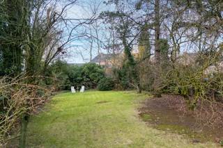 Deze charmante villa bevindt zich op een ruim perceel met een <strong>mooie parktuin</strong> en geniet van een <strong>uitstekende bereikbaarheid</strong> en zichtbaarheid. De combinatie van groen, privacy en een gunstige ligging maakt dit eigendom ideaal voor wie comfortabel wil wonen en eventueel wonen en werken wil combineren.<br /><br />Via de zijdelingse oprijlaan bereikt u de woning, met plaats voor meerdere wagens, een dubbele garage en een achterliggend magazijn. Zowel de voortuin als de afgesloten achtertuin zorgen voor een aangename buitenbeleving.<br /><br />Bij het betreden van de woning komt u in een ruime inkom- en traphal. Aan de voorzijde bevindt zich een bureauruimte met groot raam, ideaal als thuiswerkplek of praktijkruimte. De lichtrijke woonkamer beschikt over drie grote raampartijen en een elegante marmeren schouw met geïntegreerde houtkachel. Aansluitend vindt u de eetkamer, die via grote raam- en deurpartijen in verbinding staat met het terras en de tuin, en tevens toegang biedt tot de oprijlaan richting garage.<br /><br />De keuken sluit aan op de eetkamer en geeft toegang tot een gastentoilet en een wasplaats/technische ruimte met buitendeur.<br /><br />Op de eerste verdieping bevinden zich twee ruime slaapkamers en twee bijkomende kamers, evenals een badkamer met bad/douche, lavabo en toilet. De zolderverdieping, bereikbaar via een uitschuifbare trap, biedt extra bergruimte en potentieel.<br /><br />Deze woning vormt een mooie opportuniteit voor wie op zoek is naar een eigendom met karakter, ruimte en toekomstmogelijkheden in een groene, maar strategische omgeving.<br /><br /><u><strong>Voor meer info: kubra@ocvastgoed.be of 0465 08 41 48! </strong></u><br /><br />Bruto vloeroppervlakte (opgemeten volgens EPC) : 172 m<sup>2</sup> hoofdgebouw + 85 m<sup>2</sup> bijgebouw. <br /><br />Stedenbouwkundige inlichtingen: bouwvergunning, geen verkavelingsvergunning, woongebied met recreatieve karakter, geen voorkooprecht, geen gerechtelijke herstelmaatregel of bestuurlijke maatregel opgelegd.<br />Geen risicozone overstromingsgevoelig gebied. P-score = B, G-score = A,  <br />Elektriciteit niet conform <br />EPC: 813 kWh (F) <br />Renovatieverplichting