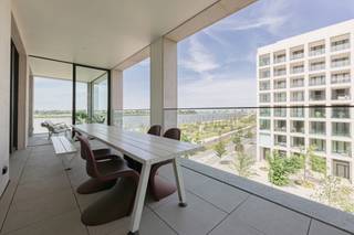 This exceptional flat is situated in one of the most sought-after locations in Nieuw Zuid, within the distinctive building designed by architect Max Dudler. Its unusually wide façade offers a direct and unobstructed view of the Scheldt, both from the living area and from the kitchen.<br /><br />The large terraces on either side of the flat offer sweeping views over Antwerp’s revitalised quays and the historic city centre. At sunrise and sunset, the panorama across the river and the city constantly shifts in atmosphere.<br /><br />Inside, the light, open-plan living area and kitchen form the beating heart of the home. Floor-to-ceiling windows allow daylight to flood in unhindered, whilst walnut and marble create a timeless, warm ambience. The kitchen, featuring an imposing marble cooking island, is as functional as it is aesthetically refined.<br /><br />The master suite serves as a private retreat, featuring a dressing room and a bathroom with a freestanding bath, walk-in shower and double washbasin, stylishly finished with Vola taps. Two additional bedrooms, served by a second fully-equipped shower room, make the flat equally suitable for a family as it is for those needing space for guests or a home office.<br /><br />Throughout the entire flat, the choice of materials reflects a refined, well-considered finish down to the smallest detail. Living comfort is complemented by three parking spaces and a spacious cellar storage room.<br /><br />Living in Nieuw Zuid means living on the banks of the Scheldt, with the refurbished quays and the historic city centre within easy reach, in a building of outstanding architectural quality. A unique opportunity for anyone looking for space, light and views in Antwerp.