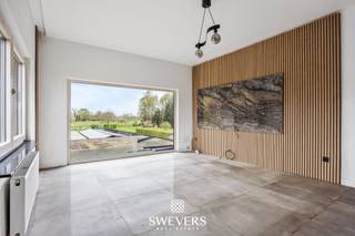 Voor meer info en foto’s, surf naar www.swevers.be – Dit ruime en instapklare appartement op de eerste verdieping in de Larenstraat 67 in Lummen werd oorspronkelijk gebouwd in 1976 en kreeg in 2022 een grondige renovatie. Met een bewoonbare oppervlakte van 123 m² en gelegen op een perceel van 14a 25ca geniet u hier van een hedendaagse afwerking, veel lichtinval en een praktische indeling. De centrale inkomhal leidt naar de lichtrijke leefruimte van 33,6 m², waar u vlot een gezellige zithoek en eethoek kan inrichten. Aansluitend bevindt zich de functionele keuken van 10 m², die mooi aansluit op het leefgedeelte. Het appartement beschikt over maar liefst 4 volwaardige slaapkamers van 11,5 m², 11 m², 11 m² en 23 m². De grootste kamer biedt extra mogelijkheden als master bedroom met dressing of bureau. In alle slaapkamers ligt parket, wat zorgt voor een warme uitstraling. De badkamer is uitgerust met een douche en er is een apart toilet aanwezig. Extra troeven zijn de privatieve garage van 20 m², de ruime gemeenschappelijke tuin van 876 m² met noordelijke oriëntatie en de aanwezigheid van 24 zonnepanelen. Ook de ligging is bijzonder praktisch, met scholen en ontspanning op 500 meter, een bushalte op 190 meter, winkels en restaurants binnen 2 km en de snelweg op slechts 2,5 km. Een ruim en verzorgd appartement met hedendaags comfort, veel mogelijkheden en een vlotte bereikbaarheid. Voor meer informatie, bel 012 699 900. Bron bewoonbare oppervlakte: EPC – verslag.