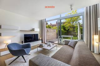 In een verborgen hoekje van het bruisende centrum van Leuven, aan een charmant en verkeersvrij pleintje, ontdekt u deze zeldzame parel: een energiezuinige stadswoning van topniveau, verscholen achter een discrete gevel. Wat volgt, is pure beleving: 170 m² wooncomfort met overvloedige lichtinval, een doordachte indeling en een afwerking tot in het kleinste detail geperfectioneerd. De leefruimte met vide en dubbelhoog raam creëert een indrukwekkend ruimtegevoel en vloeit naadloos over in de luxueus aangelegde tuin met tropisch hardhouten wanden, sfeervolle verlichting en royaal terras. De maatkeuken met granieten werkblad en ATAG-toestellen sluit hier elegant op aan. Boven vindt u drie ruime slaapkamers, twee luxueuze badkamers, een lichtrijke bureauruimte met zicht op de tuin, een praktische berging, twee nachthallen met plafondhoge kasten (14lm in totaal) en een overvloed aan functionele details: massief eiken parket, domotica (o.a. Niko Home Control 2.0), ventilatiesysteem, elektrische gordijnen, designverlichting, Cat6-netwerk, videodeurbel, veiligheidscamera’s, overal vliesbehang voorzien en professioneel geschilderd… Alles in perfecte staat, volledig instapklaar. Kelderberging en twee fietsenstallingen inbegrepen.<br />Zeldzaam voor centrum Leuven: mogelijkheid tot aankoop zeer nabije ondergrondse autostaanplaats met privé EV-laadpunt (3-fasig; 2024). Een unieke urban woning waar luxe, rust en architectuur samenkomen. Een aanrader! Contacteer ons voor verdere details.