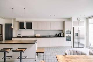 Deze unieke woning uit 1926, naar ontwerp van de gerenommeerde architect Hilaire De Boom, ademt de <strong>elegantie en verfijning</strong> van het interbellum. De Boom, bekend om zijn talrijke <strong>art-deco realisaties</strong>, drukte met deze woning opnieuw zijn stempel op het architecturale erfgoed waar Sint-Niklaas vandaag nog steeds trots op mag zijn. <strong>Authentieke elementen</strong> worden hier harmonieus gecombineerd met <strong>hedendaags comfort</strong>, wat resulteert in een bijzonder stijlvolle en instapklare woonst.<br /><br />Bij het betreden van de woning wordt u verwelkomd in een inkomhal waar de authentieke elementen meteen in het oog springen. Aan uw rechterkant  bevindt zich een <strong>praktische berging</strong>. Wanneer u verder door de hal loopt, opent de woning zich naar een <strong>lichtrijke open keuken</strong> met een groot schuifraam dat directe toegang biedt tot de <strong>gezellige stadstuin</strong>: de plek bij uitstek om te genieten van een mooie zomeravond. De <strong>sfeervolle leefruimte</strong> bevindt zich aan de straatkant. Onder de trap bevindt zich bovendien de toegang tot de kelder die extra bergruimte biedt.<br /><br />De eerste verdieping omvat <strong>drie volwaardige slaapkamers</strong>, een badkamer met douche en lavabo, een afzonderlijk toilet op de nachthal en een praktische wasplaats. Daarnaast is er toegang tot een aangenaam terras, perfect om tot rust te komen.<br /><br />Op de bovenste verdieping bevindt zich een <strong>charmante zolderkamer met en-suite badkamer</strong>, uitgerust met douche, lavabo en toilet. Deze verdieping biedt bovendien toegang tot een prachtig dakterras met jacuzzi. <br /><br /><em>Er is de mogelijkheid om vlak bij de woning 1of 2 garagebox(en) aan te kopen. </em><br /><br />Deze woning is een buitenkans voor wie op zoek is naar een <strong>karaktervolle thuis met een verhaal, gecombineerd met hedendaagse luxe en ruimte</strong>. Interesse? Contacteer ons voor een bezoek en laat u verrassen door deze bijzondere eigendom. Bel 0476 21 35 46 of mail naar laurens@claves.be.