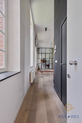 Dans les bois de Lovenjoel, nous trouvons ce fantastique appartement de plain-pied avec deux chambres à coucher.<br /><br />Il est situé dans un projet unique, entouré par la nature et avec une grande valeur patrimoniale. En plus de ça, l'intérieur a été si bien conçu qu'il a été recommandé dans un magazine d'intérieur.<br /><br />En entrant dans l'appartement, on remarque immédiatement les matériaux chaleureux, les hauts plafonds et la lumière abondante. Cela crée une ambiance énorme qui ne peut pas être facilement comparée à ce qui est proposé sur le marché aujourd'hui. À l'origine, l'appartement était agencé en 3 chambres à coucher, mais le plan a été redessiné pour créer deux chambres plus grandes. Aujourd'hui, l'une de ces chambres est utilisée comme bureau.<br /><br />Le salon spacieux avec accès à la terrasse et jardin est également relié à la cuisine ouverte, à un grand débarras technique, au hall, aux toilettes et au vestiaire encastré. À côté du salon, nous trouvons ensuite le bureau/chambre à coucher et un court couloir menant à la très grande chambre principale et à une salle de bains attenante avec baignoire, douche à l'italienne et toilettes. Celle-ci a également été joliment décorée avec une fresque murale.<br /><br />L'appartement est chauffé au gaz et dispose d'une place de parking privée et d'une cave. Il y a aussi un local à vélos commun. Entouré par la nature et même un espace bien-être, cet endroit offre tout ce qu'il faut pour se détendre.<br /><br />Contactez-nous pour une visite sur place.