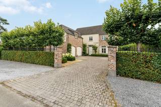 Prachtige villa met 6 slaapkamers op een mooi perceel van 1.329 m². Op het gelijkvloers ruime leefruimte met eetkamer, salon, ingerichte keuken met ontbijthoek, wasplaats en dubbele inpandige garage. Op de eerste verdieping bevinden zich 3 slaapkamers, badkamer, dressing en apart toilet en via een aparte trap nog een logeerkamer met ensuite douchekamer. Op de zolderverdieping bevinden zich nog 2 extra slaapkamers en de CV-ruimte.<br /><br />Mooie, diepe tuin met prachtig zonneterras, siervijver en tuinhuis.<br /><br />Indeling gelijkvloers:<br />Via de ruime inkomhal met gastentoilet heeft u onmiddellijk toegang het woongedeelte. Deze is zeer ruim opgevat en bestaat uit een lichte eetkamer met prachtig zicht over de tuin en een gezellige zitkamer met inbouwcassaette (op gas). Vanuit alle leefruimten heeft u een prachtig zicht op de aangelegde tuin met siervijver achteraan.<br />Aansluitend aan de eetkamer bereiken we de luxe leefkeuken voorzien van een gaskookplaat (6 pits), heteluchtoven, microgolfoven, stoomoven, vaatwasser en Amerikaanse koelkast (overname in overleg). <br />Tevens is er een ruime en praktische bijkeuken/wasplaats en een dubbele inpandige garage.<br />Eerste verdieping:<br />Via een aparte trap in de bijkeuken komt u in een aparte logeerkamer met aansluitend douchekamer (douche, wastafel en toilet) boven de garage.<br />Via de trap in de inkomhal komt u op de 1ste verdieping en hier biedt de nachthal toegang tot 3 slaapkamers op deze verdieping. Deze zijn allen voorzien van op maat gemaakte kasten en de hoofdslaapkamer is voorzien van een ruime dressing. Verder is er nog een apart toilet en een volledig ingerichte badkamer (dubbele wastafel, douche en ligbad). <br />Tweede verdieping:<br />Via een vaste trap komen we tot dit volwaardige extra verdiep. Hier treffen we de Cv-ruimte en nog 2 extra slaapkamers, waarvan één voorzien van op maat gemaakte kasten.<br /><br />BIJZONDERHEDEN<br />- Alarmsysteem<br />- 20 zonnepanelen + batterij<br />- CV op aardgas<br />- Grondwaterput aanwezig (voor automatische beregening van de tuin – 5circuits)<br />- Zuidgerichte tuin