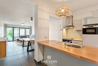 Voor meer info en foto’s, surf naar www.swevers.be – Aan de Luikersteenweg 324 in Hasselt vindt u dit instapklare gelijkvloerse appartement met één slaapkamer, privatieve staanplaats en een ruim terras met achterliggend groen. Het appartement maakt deel uit van een kleinschalig gebouw met slechts vier entiteiten, wat zorgt voor beperkte gemeenschappelijke kosten en een aangename woonomgeving.<br />Met een bewoonbare oppervlakte van 72 m² biedt dit appartement een praktische en lichtrijke indeling. De leefruimte van ca. 26,5 m² vormt het hart van de woning en geniet dankzij de grote raampartij van veel natuurlijk licht en zicht op het terras en het achterliggende groen.<br />Aansluitend bevindt zich de functionele keuken. Verder beschikt het appartement over een ruime slaapkamer van ca. 16 m², een aangename badkamer, een aparte berging en een afzonderlijk toilet. Het terras van 16 m² is een grote troef: hier geniet u volop van de rust en privacy. Het privatief gebruik van een stukje achterliggende tuin is bovendien bespreekbaar. Ook qua comfort zit u goed dankzij de gascondensatieketel en Daikin Perfera lucht-lucht warmtepompen, die zorgen voor energiezuinige verwarming en verkoeling. Winkels liggen op wandelafstand, openbaar vervoer op 120 meter en de E313 op korte afstand. Een ideale kans voor starters, alleenstaanden of investeerders die comfortabel en centraal willen wonen in Hasselt. Voor meer informatie, bel 011 255 155. Bron bewoonbare oppervlakte: EPC – verslag.