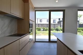 Deze prachtige nieuwbouwwoning combineert een uitstekende ligging met hedendaags wooncomfort. Gelegen op een steenworp van het Provinciedomein Bergelen, geniet u hier van een rustige, groene omgeving én een vlotte bereikbaarheid dankzij de nabijheid van het centrum en belangrijke invalswegen.<br /><br />Indeling als volgt:<br />Bij het betreden van de woning wordt u verwelkomd in een ruime, lichtrijke inkomhal die meteen een gevoel van openheid creëert. Hier is een vestiaire alsook een apart toilet voorzien.<br /><br />De gezellige leefruimte baadt in het natuurlijke licht en biedt een mooi uitzicht op de tuin. Aansluitend bevindt zich de volledig uitgeruste keuken, voorzien van alle toestellen incl. vaatwasser.<br /><br />Verder beschikt het gelijkvloers over een praktische garage met elektrische sectionaalpoort en een geïntegreerde wasplaats.<br /><br />Via de trap bereikt u de verdieping. Hier bevinden zich 3 volwaardige slaapkamers. De badkamer is uitgerust met een inloopdouche, ligbad én dubbele wastafel.<br />Afzonderlijk toilet.<br /><br />Zalig stukje tuin waar genieten centraal staat alsook reeds aangelegd terras.<br /><br />Surplus is er nog een oprit die parkeerplaats kan bieden aan 1 wagen.<br />In de straat is er bovendien héél wat gratis parkeergelegenheid voorzien.<br /><br />Afwerking met kwalitatieve materialen.<br />Reeds 8 zonnepanelen voorzien!<br /><br />Aankoop onder BTW-stelstel 21% (afgebeelde prijs is exclusief kosten en BTW)<br /><br />Onze ref. DEV5215
