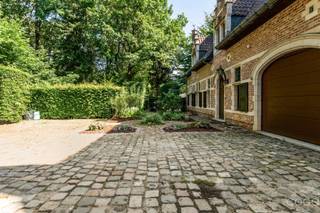 <p>Op het einde van een rustige, doodlopende straat bevindt zich deze karaktervolle kasteelvilla, bereikbaar via een stijlvolle inkompoort en een oprijlaan. De woning is gelegen op een prachtig perceel van 2.301 m² en geniet van maximale rust, privacy en een groene omgeving.</p>
<p>Via de royale inkomhal met statige trap betreedt u de woning. De sfeervolle leefruimte van ca. 66 m² straalt authenticiteit uit dankzij de Franse haard, natuurstenen kasteelvloeren en de open vide. De keuken (ca. 16 m²) biedt uitzicht op de veranda en het overdekte zwembad, waar zich tevens een douche en toilet bevinden. Verder beschikt het gelijkvloers over een gastentoilet en een inpandige dubbele garage.</p>
<p>De eerste verdieping omvat een ruime overloop en twee royale slaapkamers, elk met een eigen ensuite badkamer, en een aparte berging. Via een draaitrap bereikt u de zolderverdieping, waar zich nog twee ruime kamers en een bijkomende badkamer bevinden.</p>
<p>De prachtig aangelegde tuin vormt een oase van rust en biedt een uitzonderlijke combinatie van groen, privacy en ruimte.</p>
<p>Dit uniek eigendom dient gerenoveerd te worden, maar biedt een zeldzame kans om een karaktervolle villa met kasteelallure volledig naar eigen smaak en hedendaagse normen te renoveren. Een uitzonderlijk pand voor wie op zoek is naar charme, ruimte en een exclusieve ligging.</p>