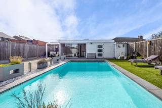 Deze halfopen woning ligt centraal in een recente, kindvriendelijke verkaveling in Oud-Turnhout. De praktische indeling en tuin met zwembad maken dit een fijne thuis voor gezinnen.

Via de inkomhal met gastentoilet kom je in de leefruimte met zit- en eethoek en aansluitende keuken. De inpandige garage met automatische sectionaalpoort biedt plaats aan je wagen en extra opbergruimte.

Op de verdieping bevinden zich drie slaapkamers, een afzonderlijke bureaukamer en een extra kamer die bijvoorbeeld als dressing kan worden ingericht. De badkamer beschikt over een inloopdouche, een toilet en aansluitingen voor wasmachine en droogkast.

In de tuin ligt een zwembad van circa 4 bij 8 meter, voorzien van een automatisch solarscherm. De terrasoverkapping met glazen schuifwanden biedt een beschutte plek om langer van het buitenleven te genieten. Elektrische screens en airco zorgen voor extra comfort. Het bijgebouw biedt ruimte voor hobby’s of fitness, naast een technische berging.

De woning werd opgeleverd in 2017, staat op een  omheind perceel van 391 m², de tuin en oprit zijn bereikbaar via een riante automatische poort. Zonnepanelen, een thuisbatterij en ventilatie met warmterecuperatie maken de woning bijzonder energiezuinig.

Een centraal gelegen gezinswoning met extra ruimte om thuis te werken en een tuin waar je volop kunt ontspannen.