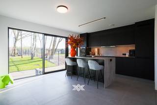 Deze nieuwbouwwoning, met drie slaapkamers en een bewoonbare oppervlakte van 144 m², bevindt zich op een zonnig perceel van 465,13 m² in de Biebuyckstraat te Nevele. De ligging is bijzonder gunstig dankzij de nabijheid van het dorpscentrum, op wandelafstand, en de vlotte verbinding met de E40. De omgeving biedt een aangename woonkwaliteit met een gevarieerd aanbod aan voorzieningen, waaronder horecazaken, supermarkten, lokale winkels en sportfaciliteiten.<br /><br /><strong>Indeling gelijkvloers</strong><br />Op het gelijkvloers bevinden zich een inkomhal met gastentoilet, een lichtrijke eet- en leefruimte en een volledig geïnstalleerde open keuken met keukeneiland, uitgerust met hoogwaardige Miele-inbouwtoestellen. Aansluitend aan de keuken is er een ruime berging. Vanuit de leefruimte geven grote raampartijen toegang tot het terras en de zuidwestelijk georiënteerde tuin, waardoor u binnen geniet van overvloedig daglicht en een fraai uitzicht op het groen.<br /><br /><strong>Eerste verdieping</strong><br />De eerste verdieping omvat drie slaapkamers, een bureauruimte, een extra afzonderlijk toilet, een technische ruimte en een badkamer met ligbad, inloopdouche en dubbele wastafel.<br /><br /><strong>Project en duurzaamheid</strong><br />De woning maakt deel uit van een kleinschalige verkaveling met in totaal vijf nieuwbouwwoningen, gerealiseerd door Kepler, een gerenommeerde projectontwikkelaar met jarenlange ervaring in het bouwen van betaalbare, kwalitatieve en energiezuinige woningen.<br /><br />Bij de uitvoering wordt bijzondere aandacht besteed aan duurzaamheid en toekomstgericht wonen. Alle woningen voldoen aan de strengste energetische normen en zijn volledig vrij van fossiele brandstoffen.<br /><br /><strong>Standaard voorziene afwerking</strong><br />- 14 fotovoltaïsche panelen van minimaal 445 Wp<br />- Omvormer met batterijopslagcapaciteit van 5 kWh<br />- Verwarming via lucht/lucht-warmtepomp<br />- Geavanceerd ventilatiesysteem D+<br />- Miele-keukenapparatuur<br /><br />Kortom, deze woningen combineren comfort, duurzaamheid en een uitstekende ligging. <br /><br />Benieuwd naar deze nieuwbouwwoning in Nevele? Een persoonlijke, vrijblijvende afspraak kan via guillian@landbergh.be of 09 278 78 79.