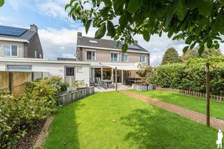 <p>Deze verzorgde halfopen gezinswoning is gelegen op een oost georiënteerd perceel van ca. 400 m² en biedt verrassend veel ruimte, licht en wooncomfort. Met 4 ruime slaapkamers, een aangename leefruimte, een praktische bijkeuken, inpandige garage en een volledig afgesloten tuin is dit een ideale woning voor gezinnen. De woning bevindt zich in een kindvriendelijke omgeving, op ca. 10 minuten van het centrum van Baarle-Hertog en op ca. 15 minuten van het centrum van Turnhout. Bovendien geniet de woning van een gunstige EPC-score van 245 kWh/m²/jaar en een conforme elektrische installatie.</p>
<p><strong>Indeling: <br /></strong>Via de inkomhal met vestiaire en apart gastentoilet betreedt u de woning. Van hieruit krijgt u toegang tot de ruime en lichtrijke leefruimte. Aan de straatzijde bevindt zich een gezellige zithoek met voldoende plaats voor een ruime salonopstelling. De oorspronkelijk buitenmuur werd als sfeervolle roomdivider behouden en vormt een mooi architecturaal element tussen de zithoek en de eetkamer. Achteraan bevindt zich de ruime eetkamer, waar u dankzij de grote raampartijen geniet van veel natuurlijk licht en een aangenaam zicht op de aangelegde tuin. De grote schuifpui zorgt voor een mooie verbinding tussen binnen en buiten en geeft rechtstreeks toegang tot het zonnige terras. Aansluitend bevindt zich de kwalitatief uitgevoerde keuken met maatwerkmeubilair, een natuurstenen werkblad, ruime opbergmogelijkheden en de nodige inbouwtoestellen. Dankzij de open verbinding met de leefruimte blijft u tijdens het koken steeds in contact met familie of gasten. Vanuit de keuken bereikt u een praktische voorraadkelder, ideaal voor extra stockage. Verder beschikt de woning over een ruime bijkeuken met voldoende plaats voor wasmachine en droogkast. Deze ruimte heeft zowel een rechtstreekse toegang tot de tuin als tot de inpandige garage, wat zorgt voor bijzonder veel praktisch comfort.</p>
<p><strong>Verdieping: <br /></strong>Op de eerste verdieping bevinden zich drie ruime slaapkamers, die allen voorzien zijn van rolluiken. De badkamer is uitgerust met een ligbad en praktische maatwerkkasten met geïntegreerde wastafel en spiegel. De vaste trap leidt verder naar de volledig afgewerkte zolderverdieping, waar zich de vierde slaapkamer bevindt. Dankzij de Veluxramen met verduistering geniet ook deze verdieping van aangenaam daglicht. Deze ruimte kan uiteraard ook perfect worden ingericht als hobbykamer, speelkamer of thuisbureau.</p>
<p><strong>Tuin:<br /></strong>De volledig afgesloten tuin is zuidwest georiënteerd en vormt een heerlijke plek om van de middag- en avondzon te genieten. Het ruime terras sluit rechtstreeks aan op de leefruimte en kijkt uit over de onderhoudsvriendelijke, mooi aangelegde tuin met onder meer een volwassen notenboom. Achteraan werd een extra gezellige zithoek gecreëerd bij het tuinhuis. Vanuit de tuin is er bovendien toegang tot het nabijgelegen speelpleintje, wat deze woning extra aantrekkelijk maakt voor gezinnen met kinderen. Dankzij de volledige omheining kunnen kinderen en huisdieren veilig buiten spelen. Het tuinhuis biedt voldoende plaats voor tuingereedschap, fietsen en speelgoed, terwijl de hondentoilet en compostzone discreet achter de beplanting werden geïntegreerd.</p>
<p><strong>Bijzonderheden:</strong></p>
<ul>
<li>4 ruime slaapkamers</li>
<li>Instapklaar en verzorgd</li>
<li>Lichtrijke en verrassend ruime woning</li>
<li>Hedendaagse en sfeervolle inrichting</li>
<li>Inpandige garage</li>
<li>Praktische bijkeuken en voorraadkelder</li>
<li>Oost georiënteerd perceel van ca. 400 m²</li>
<li>Volledig afgesloten en onderhoudsvriendelijke tuin</li>
<li>Rechtstreekse toegang tot speelpleintje</li>
<li>Kindvriendelijke en rustige woonomgeving</li>
<li>Gunstige EPC-score van 245 kWh/m²/jaar</li>
<li>Elektrische installatie conform</li>
<li>Ca. 10 minuten van Baarle-Hertog en ca. 15 minuten van Turnhout</li>
</ul>