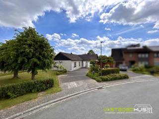 In een rustige, residentiële en kindvriendelijke woonwijk te Ninove bevindt zich deze verzorgde open bebouwing in bungalowstijl op een mooi perceel van 10a63ca. Bij het betreden van de woning komt u terecht in een lichtrijke leefruimte waar de gezellige inbouwgashaard meteen voor een warme en huiselijke sfeer zorgt. Aansluitend bevindt zich de ingerichte keuken met toestellen. Verder beschikt de woning over drie volwaardige slaapkamers, een ingerichte badkamer met zowel een ligbad als een douche en een praktische bergingszolder. Buiten geniet u optimaal van het zuidwestgericht perceel met zowel een voor- als achtertuin. De aangelegde zonneterrassen met deels overkapping en de veranda vormen de ideale plek om in alle rust van de zon en het groen te genieten. Ook op vlak van parkeermogelijkheden scoort deze eigendom uitstekend dankzij de ruime oprit met plaats voor drie wagens, een inpandige garage en een aparte houten garage. Op technisch vlak beschikt de woning over dubbele beglazing in PVC, centrale verwarming op aardgas via een condenserende gasketel, een warmtepomp lucht/lucht met koelfunctie, een conforme elektrische installatie en zonnepanelen. Dankzij deze voorzieningen behaalt de woning een gunstig EPC-label C. Bent u op zoek naar een gelijkvloerse woning met een aangename tuin, veel parkeerruimte en een uitstekende ligging in Ninove? Dan is deze eigendom zeker een bezoek waard. Voor meer informatie of een bezoek ter plaatse kunt u contact opnemen via info@vastgoedhuiseemans.be of op het nummer 054/69.68.67.