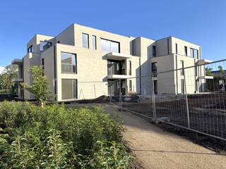 YES! Voor dit pand kan je zélf een afspraak inboeken! Ga naar de advertentie op onze website www.justwonen.be en plan meteen je afspraak in.<br /><br />Bloemenhof is een project om trots op te zijn. Echt. Want laat ons eerlijk zijn: niet élk appartementsgebouw is een meerwaarde voor ons dorp. Deze keer doen we het anders. Eindelijk. <br /><br />1. Niet wonen aan de drukte van de Grote Baan, maar in 4 kleinere residenties in een parktuin. Met respect voor de groene omgeving en de privacy van de bewoners. <br /><br />2. De appartementen werden extreem energiezuinig afgewerkt (E-peil 20), en voorzien van een warmtepomp, zonnepanelen, vloerkoeling, ventilatie, etc. Goed voor de natuur én je portemonnee. <br /><br />3. Ook ons niet-meer-zo-piepjonge publiek zetten we graag in de Bloemetjes. Erg toegankelijke appartementen, een lift tot in de parkeergarage, invalideparkeerplaatsen voor de deur en een supercentrale locatie. Even gaan lunchen in de Wouwer, een bezoekje brengen aan de bakker en beenhouwer of een tripje naar de stad met de bus: alles is op wandelafstand. <br /><br />4. De appartementen werden volledig geschilderd, dus enkel een tripje naar de Ikea, en je bent vertrokken. <br /><br />Wat dit stulpje je te bieden heeft, vraag je? <br /><br />Niet zomaar het alledaagse standaardappartement, maar een gezellig en licht stulpje van maar liefst 100 m², 3 slpk en 2 balkons! En check dat waanzinnige uitzicht op ’t groen! En als je het nog niet gespot had: dit appartement zit aan de achterzijde van het complex, dus het is er heerlijk rustig vertoeven. <br /><br />Verder is er een onderhoudsvriendelijke badkamer, 2 compacte bergingen en een apart toilet. <br />Alles wordt nog voorzien van een frisse lik verf, en ook de lampen worden bevestigd, zodat jij er zo in kan.<br /><br />En en en…dit appartement beschikt over een eigen, afgesloten garagebox in de parkeergarage. <br /><br />Maandelijkse servicekosten: 60 EUR.