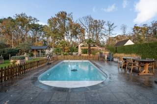 <p><strong>In een rustige, groene woonomgeving bevindt zich deze degelijk gerenoveerde villa, gelegen in een doodlopende straat op een perceel van ca. 1.100 m².</strong></p>
<p><strong>Indeling</strong></p>
<p><strong>Gelijkvloers</strong><br />Ruime inkomhal met gastentoilet en vestiaireruimte. Aansluitend bevindt zich de lichtrijke leefruimte, onderverdeeld in een sfeervol salon met TV-meubel en een royale eetkamer met lichtkoepel en grote schuiframen, die uitkijken op en directe toegang bieden tot het terras en de tuin.</p>
<p>De volledig geïnstalleerde keuken is uitgerust met een keramisch werkblad met spoelbak, gasfornuis met grote oven, dampkap en vaatwasser. Aansluitend is er een bijzonder praktische berging met ingebouwde kastenwanden.</p>
<p>Verder zijn er op het gelijkvloers een extra kamer/bureau en een polyvalente ruimte aanwezig.</p>
<p>De wasplaats is voorzien van dubbele buitendeur, wasbak en geeft toegang tot een gelijkvloerse badkamer met ligbad. Vanuit deze ruimte bereikt men via een uitschuifbare trap de geïsoleerde bergzolder, gelegen boven de inpandige garage.</p>
<p><strong>Verdieping</strong><br />Overloop met toegang tot drie slaapkamers, allen voorzien van airconditioning. De master bedroom beschikt over een ingemaakte kast.<br />De tweede badkamer is uitgerust met een inloopdouche, lavabo en toilet.</p>
<p><strong>Buitenruimte</strong><br />Het ruime terras en de fraai aangelegde, volledig omheinde tuin bieden optimale privacy. Het verwarmde zwembad wordt bediend via een recente warmtepomp.<br />Het multifunctionele bijgebouw (ca. 30 m²), bruikbaar als tuin-/werk- of hobbyruimte, is volledig onderkelderd (ca. 50 m²) met stahoogte.</p>
<p><strong>Troeven</strong><br />Een instapklare, energiezuinige woning die recent en kwalitatief werd gerenoveerd.</p>
<p><strong>Bijzonderheden</strong></p>
<ul>
<li>
<p>Renovatiejaar 2023/2024/2025</p>
</li>
<li>
<p>31 zonnepanelen met thuisbatterij (10 kW)</p>
</li>
<li>
<p>Daikin warmtepomp met airconditioning</p>
</li>
<li>
<p>Nieuwe centrale verwarming op aardgas</p>
</li>
<li>
<p>PVC- en houten ramen</p>
</li>
<li>
<p>Camerabewaking en geavanceerd alarmsysteem</p>
</li>
<li>
<p>Wifi-dekking tot in de tuin</p>
</li>
<li>
<p>Volledig vernieuwde en conforme elektrische installatie</p>
</li>
<li>
<p>Serre, moestuin, kippenren, tuinverlichting</p>
</li>
<li>
<p>Elektriciteit conform</p>
</li>
<li>
<p>EPC 202 kWh/m² – Label C – UC 20250609-0002712553</p>
</li>
<li>
<p>Vg – Wg – Gvv – Gvkr – Gmo – Gworg</p>
</li>
</ul>