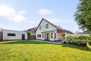 Via de inkomhal komt u in de ruime woonkamer op tegelparket met haardcassette en zicht op het bureel. Aansluitend een moderne eetkeuken (ingericht met vaatwas (BJ 2023), inductiekookplaat, koelkast (BJ 2026), combi-oven en dampkap) en afgewerkt met veel kasten en mooi werkblad. <br />Achter de keuken bevindt zich de tuinkamer met zicht op de achtertuin.<br /><br />Verder zijn er beneden nog de ruime wasplaats, een vernieuwde badkamer met inloopdouche, een apart vernieuwd toilet en een slaapkamer dewelke polyvalent ingericht kan worden.<br /><br />Op de verdieping nog 4 extra slaapkamers, een douchekamer met toilet en een bergruimte. <br /><br />Grote dubbele garage met automatische poort. <br /><br />Buitengewone kenmerken:<br />* De woning biedt veel mogelijkheden gezien ruim bureel beneden en slaapkamer en badkamer beneden. Wonen en werken van thuis uit, zorgwoning,...<br />* De woning werd in 2026 nog gerenoveerd, met name: schilderwerken benedenverdieping, nieuw toilet beneden, nieuwe badkamer beneden<br />* nieuwe CV-ketel (BJ 2026)<br />* zonnepanelen aanwezig met groenestroomcertificaten tot 2028-2029<br />* conforme elektrische keuring, geen asbest aanwezig