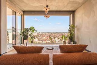 Dit exclusieve tweeslaapkamerappartement van circa 95 m² bevindt zich op de 20e verdieping van de iconische Antwerp Tower. De kamerhoge ramen zorgen voor een uitzonderlijke lichtinval en een panoramisch uitzicht over onder meer het MAS, de haven en de Antwerpse skyline.<br /><br />De Antwerp Tower ligt in het hart van de stad op wandelafstand van de Meir, het Theaterplein, winkels, restaurants en culturele hotspots. Een uiterst centrale ligging, gecombineerd met de rust en privacy van wonen op grote hoogte.<br /><br />Het appartement omvat een lichtrijke leefruimte met een volledig geïnstalleerde open keuken en rechtstreekse toegang tot het terras. Ook beide slaapkamers geven uit op het terras. Verder beschikt het appartement over een badkamer met douche en lavabomeubel, evenals een afzonderlijk gastentoilet. Het ventilatiesysteem kan gecombineerd worden met een Zehnder ComfoClime, wat het hele jaar door een aangenaam binnenklimaat garandeert.<br /><br />Bijzonderheden<br />- Gelegen op de 20e verdieping<br />- Panoramisch uitzicht over Antwerpen<br />- Zehnder ComfoClime mogelijkheid<br />- Mogelijkheid tot plaatsing airco<br />- Verkoop onder registratierechten