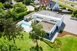 <br />Moderne luxe-villa met heel mooie tuin bestaande uit een inkomhal, living, ingerichte ruime keuken, bijkeuken, 2 slaapkamers, 2 badkamers, dressing, strijkkamer, wasplaats, dubbele garage en berging.<br />Op verdiep een appartement met aparte ingang en een living met open keuken, 3 slaapkamers, 3 badkamers, dressing en een terras.<br />Overdekt terras, zwembad en poolhouse op 5.664m². Ideaal voor kangoeroewonen. Ca. 600m² vloeroppervlakte. <br />