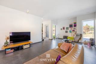 Voor meer info en foto’s, surf naar www.swevers.be – In het hart van Leopoldsburg, in een rustige en kindvriendelijke wijk, vind je deze instapklare open bebouwing uit 2017. De woning ligt op een zuidgericht perceel van 9a 31ca en biedt met 225 m² bewoonbare oppervlakte alle ruimte voor een gezin of thuiswerkend koppel. Op het gelijkvloers zorgen de lichtrijke zithoek, eetkamer en moderne keuken met kookeiland voor een open en aangename leefruimte van bijna 60 m². Een aparte bureau, berging, en gastentoilet maken het plaatje compleet. Boven bevinden zich drie ruime slaapkamers, waaronder een master met dressing, en een stijlvolle badkamer met bad, dubbele wastafel en toilet. Dankzij zonnepanelen, ventilatiesysteem en regenwaterrecuperatie woon je hier energiezuinig en comfortabel. De tuin is onderhoudsvriendelijk met automatisch besproeiingssysteem en biedt veel zonlicht, ook binnen. De ligging is top: winkels, scholen en openbaar vervoer zijn vlakbij. Deze moderne woning biedt rust, ruimte en praktisch comfort op een centrale locatie. Voor meer informatie, bel 011 255 155. Bron bewoonbare oppervlakte: EPC – verslag.