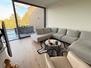 Dit nieuwbouwappartement ligt nabij het centrum, in een rustige wijk. Het heeft een bijzonder uitzicht op het Oud Gelaag, de athletiekpiste, de kerktoren en de fietsroute. De afwerking is heel mooi en elegant. De leefruimte heeft een eet- en zithoek en een groot schuifraam naar het terras. Dat is maar liefst 34m² groot! De open, moderne keuken is ingericht met toestellen en handige snufjes. Er zijn 2 slaapkamers, een badkamer met douche, een apart toilet en een berging/wasplaats. In de kelderverdieping is er een individuele en heel grote kelderberging. Bij het appartement hoort een autostaanplaats. Enkele extra's zijn: maatkasten, zonnepanelen, vloerverwarming én -koeling, gemeenschappelijke fietsenberging, gemeenschappelijke tuin, gemeenschappelijke parkeerplaatsen voor bezoekers. Dit luxueus ingericht appartement met parketvloer is helaas niet geschikt voor onze viervoetige vrienden. Als het kriebelt om een bezoek in te plannen, mail ons dan op contact@eberhardvastgoed.be.