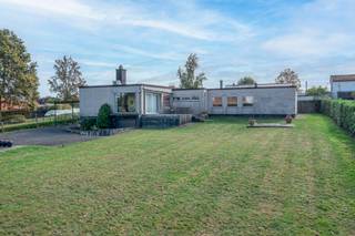 <p><strong>Vrijstaande bungalowvilla met 4 slaapkamers en prachtig uitzicht in Asse</strong></p>
<p>Deze laagbouw-villa in typische sixties-stijl is discreet gelegen op een mooi rechthoekig perceel van 22a 20ca, nabij centrum Asse en invalswegen richting Brussel en het binnenland. Dankzij de lichte helling van het terrein geniet de woning een uitzonderlijk verzicht op de groene omgeving.</p>
<p>De woning wordt betreden via een ruime, centrale inkomhal die toegang biedt tot de lichtrijke leefruimte met open haard en eetplaats. Het grote schuifraam met hoogrendementsglas in aluminium geeft uit op het zonnige terras en de tuin met prachtig uitzicht.</p>
<p>Aansluitend bevindt zich de halfopen keuken die modernisering vraagt, en een nachthall die toegang geeft tot 4 volwaardige slaapkamers, een bureel, badkamer met ligbad, wastafel en toilet, en een praktische bergruimte.</p>
<p>De woning beschikt verder over meerdere kelders en een inpandige garage. Recent werd de eigendom voorzien van een lucht-lucht warmtepomp en 14 zonnepanelen, wat zorgt voor energiezuiniger comfort.</p>
<p>Mits esthetische opfrissing heeft deze bungalow alles in huis om uit te groeien tot een unieke gezinswoning of karaktervolle villa in een bijzonder groene en rustige zone rond Asse, met zwembad!</p>
<p>Plan jouw bezoek via rune.stallaert@living-stone.be of telefonisch via 02 466 05 75</p>