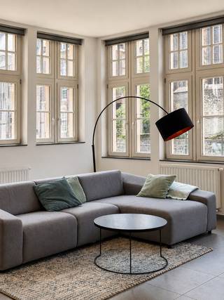 TE HUUR - GENT. Op een uitzonderlijke locatie aan het water: een charmant gelijkvloers appartement van maar liefst 142 m² aan de Predikherenlei. Het appartement bevindt zich in een karaktervol gebouw in het historische centrum en verwelkomt u via een inkomhal met apart toilet. De royale leefruimte met zit- en eethoek geniet dankzij de hoge plafonds en vele ramen van een prachtige lichtinval en een bijzonder ruimtelijk gevoel. Verder beschikt het appartement over een ingerichte keuken met handige berging, twee ruime slaapkamers en een badkamer. In het gebouw is bovendien een fietsenberging aanwezig. Een unieke woonplek waar ruimte, licht en historische charme harmonieus samenkomen, op wandelafstand van alles wat Gent te bieden heeft. De maandelijkse huurprijs bedraagt € 1.500. Zolang de straatwerkzaamheden aan de Predikherenlei duren, geldt een tijdelijk verlaagde huurprijs van € 1.250 per maand. De algemene maandelijkse kosten bedragen € 50. EPC Label C (20260810-0003928620-RES-1)