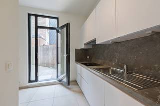 <p>Op een uiterst centrale ligging bevindt zich dit stijlvolle, volledig vernieuwde duplexappartement waar ruimte, licht en hedendaags wooncomfort perfect samenkomen. Dankzij de grote raampartijen geniet de leefruimte van een overvloed aan natuurlijk licht en een aangenaam open gevoel.<span></span></p>
<p>Via de lift bereikt u het appartement. De inkomhal met gastentoilet geeft toegang tot de ruime en lichtrijke leefruimte met een volledig ingerichte open keuken, afgewerkt met kwalitatieve materialen en voorzien van alle hedendaagse comfort. Vanuit de keuken heeft u rechtstreeks toegang tot een aangenaam terras, ideaal om buiten te genieten.</p>
<p>Verder beschikt het appartement over een praktische berging met aansluiting voor een was- en droogautomaat, evenals een aparte technische ruimte.</p>
<p>Via de trap bereikt u de bovenverdieping, waar zich twee ruime slaapkamers en een stijlvolle badkamer bevinden. Op deze verdieping is er bovendien toegang tot een tweede gezellig terras, waardoor u op elk moment van de dag van een buitenruimte kunt genieten.</p>
<p><strong> </strong></p>