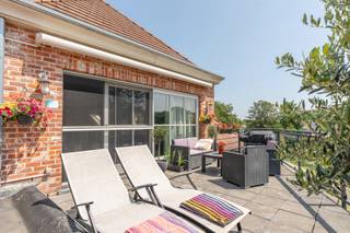 <strong>Luxeueuze penthouse met 3 slaapkamers, terras en dubbele garagebox te Turnhout</strong><br />EPC: B-label | Elektriciteit conform | Bewoonbare opp. 260 m²<br /><br /><strong>Gunstig gelegen</strong> aan de Ring van Turnhout met een vlotte bereikbaarheid naar de autostrade <strong>E34 Antwerpen-Nederland </strong>en in de nabijheid van het centrum, winkels, scholen en openbaar vervoer. Alsook op wandelafstand van een groene omgeving. <br /><br />Dit knappe en lichtrijke dakappartement beschikt over een oppervlakte van maar liefst 260 m² en een zonnig terras op het ZO van 20 m² met automatische zonneluifel. <br /><br />We betreden dit prachtige appartement via de inkomhal met gastentoilet en ruimte voor vestiaire. <br />De aangename en ruime woonkamer van 85 m² met een lichtrijke eethoek en gezellige zithoek biedt een zeer ruimtelijk gevoel door het hoge plafond en de vele ramen rondom. De mooie open keuken bestaat uit een gasvuur met dampkap, combi-oven, koelkast en vaatwasser en een groot keukeneiland van composiet waar het gezellig vertoeven is. Aansluitend aan de keuken vinden we een praktische en grote voorraadberging. Via de open trap in de woonkamer komen we terecht in de mezzanine, waar men een aangename bureauruimte, thuiswerkplek of extra zit- of leeshoek kan creëren.<br /><br />Tevens beschikt dit luxeappartement over 3 volwaardige slaapkamers, een volledig ingerichte dressing en 2 badkamers. De luxueuze badkamer is uitgerust met een ligbad, inloopdouche, badkamermeubel met dubbele wastafel en een toilet en grenst aan de masterbedroom.<br />De twee grote slaapkamers zijn verbonden door een badkamer met douche en wastafel. Ideaal voor kinderen of gasten. Verder treffen we vanuit de nachthal nog een tweede aparte wasplaats-berging.<br /><br />De grote ondergrondse <strong>garagebox </strong>met automatische poort van +\- 50 m² biedt plaats voor 2 wagens, extra berging en fietsenstalling en is inbegrepen in de verkoopprijs.
