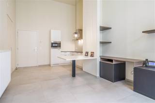 Deze erkende assistentiewoning is gelegen in het centrum van Kortrijk op amper 350 meter van de Grote Markt en op 1 minuut wandelen van het Shoppingcenter K. <br />Dankzij de onmiddellijke nabijheid van het bus- en treinstation en de belangrijkste invalswegen, is de bereikbaarheid voor u en uw bezoek optimaal. Bij het binnenkomen van de assistentiewoning is de keuze voor kwaliteit onmiddelijk merkbaar en de hoge plafonds geven een gevoel van ruimte.<br /><br />Bij binnenkomst treft u een inkomhal met ingemaakte vestiaire. De lichtrijke leefruimte sluit naadloos aan op de volledig geïnstalleerde open keuken, uitgerust met een inductiekookplaat, microgolfoven, koelkast met vriesvak, dampkap, Franke-spoelbak en vaatwasser. Dankzij de talrijke keukenkasten is er meer dan voldoende opbergruimte.<br />Het appartement beschikt over één volwaardige slaapkamer van 13,7 m² met rechtstreekse toegang tot de badkamer. Deze is ingericht met een hangtoilet, douche, lavabo met spiegel en een stijlvolle sierradiator. Tot slot is er een aparte opbergkast voorzien met aansluiting voor wasmachine en droogkast.<br /><br />Genieten kan op het gezellig inpandig terras. Geen opstapje en zalige verbinding met de levendige buurt.<br />Surplus is er nog een afgesloten fietsenstaanplaats.