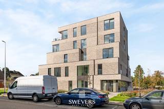 Voor meer info en foto’s, surf naar [www.swevers.be](http://www.swevers.be) — Dit instapklare appartement uit 2025 in Residentie Zwanenpark heeft een bewoonbare oppervlakte van 100 m² en bevindt zich op de eerste verdieping aan Kolmen 32A bus 4, centraal in Tessenderlo. Winkels, restaurants, scholen en openbaar vervoer liggen op wandelafstand, terwijl de snelweg zich op slechts 3,5 km bevindt. De lichtrijke leefruimte van 36,89 m² sluit direct aan op de praktische keuken van 9,11 m². Brede raampartijen geven toegang tot het ruime, westgerichte terras van 12,98 m² waar u geniet van de avondzon. Via de nachthal bereikt u twee slaapkamers van 12,03 m² en 10,02 m², de badkamer met ligbad en twee afzonderlijke toiletten. Met een inloopkast, wasberging, kelderberging van 3,45 m², lift, airco, alarm en een inbegrepen autostaanplaats geniet u van compleet wooncomfort. Maandelijkse kosten: € 112. Bel voor een afspraak naar 011 255 155. Bron bewoonbare oppervlakte: EPC-verslag.
