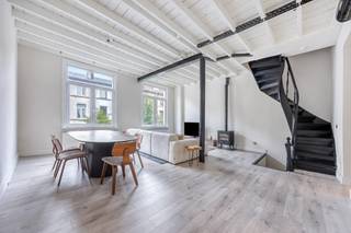<p>Rustig wonen vlak bij het bruisende stadscentrum? In de bomenrijke Brusselstraat combineert deze bijzondere stadswoning het beste van twee werelden. Op korte afstand van Troonplaats, Markgrave en het Zuid, en tegelijk uitstekend verbonden met de belangrijkste invalswegen.<br /><br />Achter de gevel ontvouwt zich een verrassend open woning met ca. 197 m² bewoonbare oppervlakte. Hoge plafonds, zichtbare balken, grote raampartijen en de open indeling geven het geheel een uitgesproken loftgevoel.<br /><br /><strong>Open wonen met karakter</strong><br /><br />De leefverdieping vormt het hart van de woning. De zit- en eetruimte lopen naadloos in elkaar over en sluiten aan op de volledig ingerichte open keuken. Dankzij de hoge plafonds en overvloedige lichtinval voelt deze verdieping bijzonder ruim en open aan.<br /><br />De zichtbare balkenstructuur geeft het interieur karakter, terwijl de strakke afwerking en open verbinding tussen de verschillende ruimtes zorgen voor een eigentijdse uitstraling. Het resultaat is een woning die duidelijk anders aanvoelt dan de klassieke Antwerpse stadswoning.<br /><br /><strong>Twee slaapkamers en stijlvolle badkamer</strong><br /><br />Op de bovenliggende verdieping bevinden zich twee slaapkamers. Ook hier zorgen de volumes en natuurlijke lichtinval voor een aangenaam ruimtegevoel.<br /><br />De badkamer is stijlvol ingericht en beschikt over zowel een vrijstaand ligbad als een ruime inloopdouche.<br /><br /><strong>Een dakterras om echt te gebruiken</strong><br /><br />Helemaal boven bevindt zich misschien wel de fijnste plek van het huis. Het dakterras van ca. 45 m² vormt tijdens de warmere maanden een volwaardige extra leefruimte.<br /><br />Hier geniet je van ’s morgens tot ’s avonds van de zon. Bovendien bevindt zich direct naast het terras een bijkomende keuken. Ideaal voor een uitgebreid ontbijt buiten, een zomers diner of een aperitief met vrienden zonder telkens enkele verdiepingen naar beneden te moeten.<br /><br /><strong>Uitzonderlijk ruime inpandige garage</strong><br /><br />Een absolute luxe zo dicht bij het centrum: de woning beschikt over een zeer ruime inpandige garage met comfortabel plaats voor twee wagens én heel wat bijkomende ruimte achteraan.<br /><br />Fietsen, sportmateriaal, extra opslag of hobbygebruik vinden er moeiteloos hun plek. In combinatie met de grote kelder beschikt deze woning over uitzonderlijk veel praktische ruimte voor een stadswoning.<br /><br /><strong>Rustig én centraal</strong><br /><br />De Brusselstraat is een rustige, bomenrijke straat, terwijl het Antwerpse stadsleven zich vlakbij bevindt. Troonplaats en Markgrave liggen op korte afstand, het Zuid bereik je in ongeveer vijf minuten en ook het historische centrum is vlot bereikbaar.<br /><br />Tegelijk zit je hier strategisch ten opzichte van de belangrijkste invalswegen. Je woont dus dicht bij alles wat Antwerpen aantrekkelijk maakt, zonder voor elke verplaatsing de halve stad te moeten doorkruisen.<br /><br />Een bijzondere stadswoning voor wie het open gevoel van een loft zoekt, maar niet wil inboeten aan buitenruimte, parking, bergruimte of een centrale ligging.<br /><br />Bijzonderheden: ca. 197 m² bewoonbare oppervlakte | ca. 45 m² dakterras | 2 slaapkamers | 2 keukens | zeer ruime inpandige garage voor 2 wagens + extra ruimte | grote kelder | EPC C – 215 kWh/m² | bouwjaar 1918 | instapklaar.<br /><br />Voor meer informatie of een bezoek ter plaatse kan u contact opnemen met Vincent via 0475/21.00.86 vincent@reds.be</p>