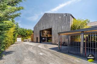 Karaktervol gerenoveerd vastgoedcomplex bestaande uit een stijlvolle woning met bureelruimte, een achterliggend magazijn, gunstig gelegen aan de Maastrichtersteenweg 244-246 te Tongeren.<br /><br />Dankzij de uitstekende ligging langs de gewestweg N79 tussen Riemst en Tongeren, en op korte afstand van de autosnelweg, geniet deze eigendom van een vlotte bereikbaarheid.<br />Winkels en dagelijkse voorzieningen bevinden zich op enkele autominuten.<br />Het geheel is gelegen op een perceel van 14a 20ca en biedt tal van mogelijkheden, waaronder privébewoning gecombineerd met kantoor- of praktijkruimte.<br />Zowel vooraan als op het terrein zelf is ruime parkeergelegenheid voorzien.<br /><br /><u><strong>Woning met bureelruimte:</strong></u><br />De authentieke woning (186 m²), gecombineerd met een bureelgedeelte van ca. 70 m², werd met oog voor detail gerenoveerd waarbij het oorspronkelijke karakter zorgvuldig bewaard bleef. De ruime indeling, overvloedige lichtinval en stijlvolle afwerking zorgen voor een bijzonder aangename woon- en werkomgeving.<br /><br />Via de centrale inkomhal bereikt men enerzijds het private woongedeelte en anderzijds de bureelruimte.<br />Het woongedeelte omvat een royale en lichtrijke leefruimte, aansluitend op een volledig ingerichte landelijke keuken met ruime eethoek en een prachtig zicht op de binnentuin, bereikbaar via een schuifpui. Verder beschikt de woning over een praktische berging.<br /><br />Op de eerste verdieping geeft de overloop toegang tot de master bedroom met geïntegreerde dressing en een ensuite badkamer uitgerust met een vrijstaand ligbad, wastafel, ruime inloopdouche en afzonderlijk toilet.<br />De tweede slaapkamer beschikt over een naastgelegen bureelruimte en biedt doorgang naar de wasruimte.<br /><br />De tweede verdieping (82m²) werd reeds voorbereid voor verdere afwerking tot twee bijkomende slaapkamers met dressing en badkamer.<br />De vloer is voorzien van OSB-platen en de wanden en plafonds werden afgewerkt met gipsplaten.<br /><br />Daarnaast is de woning grotendeels onderkelderd (ca 85m²) en beschikt zij over diverse praktische bergruimtes.<br /><br />De kantoorruimte omvat een indrukwekkende nokhoge bureelruimte, een extra kantoor, kitchenette en gastentoilet. Via de sfeervolle binnentuin staat deze ruimte bovendien in directe verbinding met het achtergelegen magazijn.<br />Voorzien van alarm en camerabewaking. <br /><br /><u><strong>Magazijn:</strong></u><br />Het magazijn (382 m²) is bereikbaar via een automatische toegangspoort en omvat een ruime opslagplaats, afzonderlijke bureelruimte. Op de verdieping is er bijkomende opslagruimte en een bergruimte.<br />Achteraan bevindt zich overdekte opslagruimte (21m²). Het gebouw is uitgerust met twee sectionaalpoorten.<br /><br /><br /><u>Belangrijkste troeven van deze aanbieding zijn:</u><br /><br />- Uitstekende ligging langs de N79 tussen Riemst en Tongeren, nabij de autosnelweg.<br />- De voorgelegen weg wordt binnenkort volledig heringericht met extra groenvoorzieningen, wat de omgeving en uitstraling aanzienlijk zal versterken.<br />- Uniek vastgoedcomplex bestaande uit woning, burelen en magazijn.<br />- Veelzijdig inzetbaar voor privébewoning, kantoor, praktijkruimte of combinatie van wonen en werken.<br />- Ruime parkeermogelijkheden op eigen terrein.<br /><br /><br />Voor meer info of een bezoek ter plaatse, contacteer ons op 0473 79 29 30 of mail naar luc@vestio.com <br /><br /><br /><br /><br /><br /><br /> 