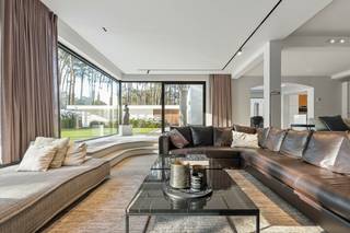 <p>Quares - TREVI Groep presenteert :<br />Voor deze knappe eigendom klinken superlatieven te bescheiden. Het is werkelijk indrukwekkend, fenomenaal, magnifiek! Voor wie houdt van discretie, rust, luxe en privacy.</p>
<p>Na een 70m lange oprijlaan verschijnt een elegante gevel die je onmiddellijk doet dromen: je waant je in de Hamptons, New York. De recent vernieuwde gevelbekleding doet de woning schitteren in haar nieuwe jasje. Een lang bordes nodigt je uit om de woning te ontdekken.</p>
<p>Binnen kijk je je ogen uit in de royale inkomhal met keizerlijke trap, die naar de bibliotheek en slaapvertrekken leidt.</p>
<p>GELIJKVLOERS:</p>
<p>In de rechtervleugel bevinden zich de dubbele garage met berging, vestiaire, en de logeerkamer met en suite gastenbadkamer.</p>
<p>In de linkervleugel ligt de bureauruimte waar het rustig werken is, en die ruim genoeg is om klanten op aangename wijze te ontvangen; en een gastentoilet.</p>
<p>Aan de achterzijde bevindt zich de gigantische leefruimte met keuken: het kloppende hart van de woning, met een adembenemend zicht op de tuin.</p>
<p>Dit deel is bijzonder stijlvol vernieuwd, met een hedendaagse look &amp; feel en hoogwaardige materialen. Een grote gashaard, gezellige zitput, gimmicks zoals een verdwijnend raam en doorkijk naar de keuken, maken dat deze ruimte op verschillende momenten van de dag anders aanvoelt. Het grote panoramische raam is als een landschapsschilderij, maar dan van de eigen tuin. De keuken is volledig geëquipeerd en wordt geflankeerd door een enorm overdekt terras, waardoor het binnen-buitengevoel compleet is. Dit is een woning waar je kan genieten, en je graag veel tijd in wil doorbrengen.</p>
<p>VERDIEPING:</p>
<p>Linkervleugel: hier bevindt zich de grootste badkamer, een behoorlijk futuristisch ontwerp met centraal element waarrond de verschillende functies zich bevinden: ruime douche, hoekbad, dubbele lavabo, omkleedhoek. Aansluitend bevindt zich een praktische wasplaats, strijkruimte en apart toilet.</p>
<p>Een dressing leidt naar de comfortabel ruime master bedroom met zicht op de tuin, die naar een tweede open dressing of extra slaapkamer leidt. Ernaast bevindt zich een fitnessruimte die een derde slaapkamer kan zijn.<br /><br />In de rechtervleugel bevinden zich 2 prachtige ruime slaapkamers met mezzanine - een droom voor vele tieners – en een derde badkamer met ligbad en douche completeert het geheel.</p>
<p>Samen komen we op 6 slaapkamers in het totaal, 5 boven en 1 beneden, plus een dressing boven en bureau beneden. Ideaal voor wie ruim wil wonen, samengesteld gezin, werken &amp; wonen, B&amp;B en wonen, etc.</p>
<p>KELDER</p>
<p>Uiterst praktisch is de enorme kelder die deels verwarmd is, met hobbyruimtes, wijnkelder en opslagruimtes. Verder is er nog een kruipkelder.</p>
<p>TUIN:</p>
<p>In de tuin aansluitend aan de oprit, bevindt zich een bijgebouw met aparte fietsenberging, berging voor alle tuinonderhoudsmaterialen, en ruimte voor sport en ultieme ontspanning: een zwemspa met jetstream &amp; onderwaterloopband, en een heerlijke jacuzzi. Wellness in eigen tuin. De tuin zelf is een prachtig glooiend gazon met zuid-zuidwest oriëntatie, omzoomd met struiken, bloemen en grote bomen. Mooi aangelegd èn beperkt in onderhoud zodat je er ook echt van kan genieten.</p>
<p>Halverwege de tuin loopt het hoofdperceel over in 2 percelen bouwgrond (85B en 85C op het bijgevoegde plan), die mee aangekocht kunnen worden aan respectievelijk 300.000EU en 325.000EU, maar die niet allebei absoluut noodzakelijk zijn om het weidse aspect te behouden.</p>
<p>Technisch is deze woning uitgerust met warmtepompen, airco, dak- en muurisolatie, hoogrendementsglas, alarm en camera’s, domotica, een conforme state-of-the-art elektrische installatie, en mèt een EPC A, wat zeer uitzonderlijk is voor dit type woning en uiteraard een enorme troef!</p>
<p>Geïnspireerd en klaar om deze droomwoning te ontdekken? Maak dan een afspraak met Tinne op 0477 60 21 99 of tinne.schotsmans@quares.be</p>