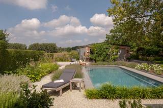 <p><strong>Volledig gerenoveerde woning met 5 slaapkamers, zwembad en prachtig aangelegde tuin op 1.643 m².</strong></p>
<p><strong>BEKIJK ZEKER ONZE (VIRTUELE) GRONDPLANNEN EN ATTESTEN VOOR DE INDELING EN EXTRA INFORMATIE.</strong></p>
<p>Bent u op zoek naar een ruime en volledig gerenoveerde woning met een uitzonderlijk aangename tuin en een vrij uitzicht achteraan? Dan is deze karaktervolle woning in Hombeek zeker een bezoek waard. <br /><br />Met een bewoonbare oppervlakte van maar liefst 359 m², vijf slaapkamers, twee badkamers, een afzonderlijke bureauruimte en dressing biedt de woning bijzonder veel ruimte voor een gezin of kan dienst doen als kangoeroewoonst. De woning onderging in 2014 een totaalrenovatie en combineert het karakter van de oorspronkelijke woning met een hedendaagse en verzorgde afwerking. De ruime leefruimte met haard sluit mooi aan op de lichtrijke eetplaats en de volledig uitgeruste keuken met kookeiland. Grote raampartijen zorgen voor een sterke verbinding met het terras en de fraai aangelegde tuin. <br /><br />Buiten vormt het perceel van 1.643 m² een absolute troef. De tuin werd in 2019 volledig aangelegd en beschikt over verschillende terrassen, een vijver, volwassen beplanting en een verwarmd zwembad van 8 x 4 meter. Achteraan geniet u bovendien van een prachtig open zicht over de omliggende velden.<br /><br />Ook technisch staat de woning sterk met EPC-label A, conforme elektriciteit, 26 zonnepanelen, ventilatiesysteem D en een laadpaal. Het asbestattest vermeldt de woning als asbestveilig.<br /><br />De woning combineert een rustige, groene ligging met een uitstekende bereikbaarheid dankzij de vlotte verbinding naar Mechelen, de A12 en de E19. Winkels, scholen en openbaar vervoer bevinden zich bovendien in de nabije omgeving.</p>
<p><strong>ALGEMENE KENMERKEN:</strong></p>
<ul>
<li><span>Totaalrenovatie uitgevoerd in 2014</span></li>
<li>Rustige, landelijke ligging in Hombeek met een uitstekende bereikbaarheid naar Mechelen, de A12 en de E19, en nabij winkels, scholen en openbaar vervoer</li>
<li>5 slaapkamers, 2 badkamers, aparte bureauruimte en dressing</li>
<li>Royale leefruimte, eetkamer en volledig uitgeruste keuken</li>
<li>Prachtig aangelegde tuin met verschillende terrassen, vijver en volwassen beplanting</li>
<li>Verwarmd zwembad (warmtepomp, 2025) van 8 x 4 meter, aangelegd in 2019</li>
<li>Open en landelijk uitzicht achteraan</li>
<li>Voldoende parkeerplaatsen</li>
</ul>
<p><strong>TECHNISCHE KENMERKEN:</strong></p>
<ul>
<li>Zeer gunstige EPC-score: 69 kWh/(m²/jaar) - Label A</li>
<li>Elektrische installatie woning conform AREI - 3-fasen</li>
<li><span>Asbestveilig</span></li>
<li>Centrale verwarming op aardgas</li>
<li>26 zonnepanelen (2019) – opbrengst van ca. 7.000 kWh/jaar</li>
<li><span>Ventilatiesysteem type D</span></li>
<li><span>Laadpaal</span></li>
<li>Regenwaterput van 10.000 liter</li>
<li>Elektrische zonnescreens en rolluiken aan de zuidkant</li>
<li><span>Videofoon</span></li>
<li><span>Aansluiting alarminstallatie</span></li>
</ul>
<p><strong>INDELING:</strong></p>
<p><u>Gelijkvloers</u></p>
<ul>
<li>Ruime inkomhal met apart toilet</li>
<li>Grote leefruimte met zithoek en haard</li>
<li>Lichtrijke eetplaats met directe verbinding naar terras en tuin</li>
<li>Ruime, volledig uitgeruste keuken met centraal kookeiland</li>
<li><span>Afzonderlijke bureau- of praktijkruimte</span></li>
<li>Eerste badkamer met douche, toilet en lavabo</li>
<li><span>Wasplaats en berging</span></li>
</ul>
<p><u>Eerste verdieping</u></p>
<ul>
<li><span>Nachthal</span></li>
<li><span>Meerdere ruime slaapkamers</span></li>
<li><span>Dressing</span></li>
<li>Tweede badkamer met inloopdouche, ligbad en lavabo</li>
<li><span>Afzonderlijk toilet</span></li>
</ul>
<p><u>Tweede verdieping</u></p>
<ul>
<li><span>Ingerichte zolderruimte / slaapkamer</span></li>
</ul>