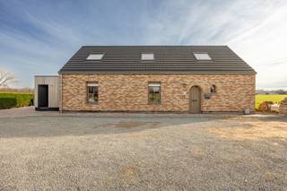 INDELINGGELIJKVLOERSInkomhal met vestiaireruimte en omvormer van de zonnepanelen. Toiletruimte. Woonkamer met sierhaard en bureauruimte. Keuken...