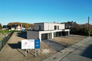 Deze nieuwbouw woning met 3 slaapkamers en een bewoonbare oppervlakte van 184 m² is gelegen op een perceel van 703 m² langs de Rijksweg in Machelen, een deelgemeente van Zulte. Deze gemeente is centraal gelegen tussen Deinze en Kortrijk en staat bekend om zijn mooie natuur en uitgestrekte fiets- en wandelroutes langs het water, waardoor het erg geliefd is bij fietsers, wandelaars en natuurliefhebbers. Daarnaast biedt de regio een mooi aanbod aan horeca, diverse supermarkten, detailhandel, sportfaciliteiten,...<br /><br />De woning is op het gelijkvloers ingedeeld als volgt: een inkomhal met gastentoilet en plaats voor een vestiairekast, via de kamerhoge glazen deur (type steellook) komt u in de lichtrijke eet- en leefruimte met volledig geïnstalleerde open keuken, voorzien van een keukeneiland en uitgerust met diverse inbouwtoestellen waaronder een Bora fornuis met ingewerkte dampkap. Aansluitend aan de keuken bevindt zich een inpandige garage met ruime annex berging. De westelijk georiënteerde tuin met terras is te bereiken vanuit de leefruimte. Dankzij de grote raampartijen kunt u binnen genieten van een mooie natuurlijke lichtinval en een uitzicht over de tuin.<br /><br />Op de eerste verdieping zijn er drie slaapkamers, samen met een extra afzonderlijk toilet, een technische ruimte en een badkamer voorzien van een ligbad, ruime inloopdouche en een dubbele wastafel.<br /><br />Deze woning maakt deel uit van een kleine verkavelde grond waarop er 6 nieuwbouwwoningen zullen komen. Twee woningen werden ondertussen volledig afgewerkt, twee andere zitten in ruwbouwfase en er zijn ook nog twee woningen waar de bouwwerken nog moeten starten. In de laatste twee gevallen kunnen alle keuzes op het vlak van afwerking nog zelf gemaakt worden volgens de ruime budgetten die in het lastenboek standaard worden voorzien.<br /><br />Deze woningen voldoen aan de strenge energetische normen en onderscheiden zich onder meer door hun duurzaam karakter, vrij van fossiele brandstoffen. Er wordt gebruik gemaakt van fotovoltaïsche panelen (5 stuks), vloerverwarming door middel van een warmtepomp (lucht-water) en een sterke akoestische en thermische isolatie. Bovendien worden de woningen uitgerust met een ventilatiesysteem type D met maximale warmterecuperatie. Iedere woning beschikt tevens over een septische put van 2.000 liter en een regenwaterput van 10.000 liter.<br /><br />Lot 3: oppervlakte perceel 336 m² - bewoonbare oppervlakte 187,26 m²<br />Lot 4: oppervlakte perceel 501 m² - bewoonbare oppervlakte 173,70 m²<br />Lot 5: oppervlakte perceel 703 m² - bewoonbare oppervlakte 184,04 m²<br />Lot 6: oppervlakte perceel 578 m² - bewoonbare oppervlakte 186,99 m²<br /><br />Verlaagd BTW-tarief van 6% mogelijk op de volledige constructiewaarde. <br /><br />Benieuwd naar één van deze lichtrijke en kwalitatieve nieuwbouwwoningen? Maak dan snel een vrijblijvende afspraak via guillian@landbergh.be of 09 278 78 79