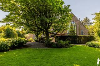 <p><strong>Prachtige villa met een bewoonbare oppervlakte van 512 m²</strong></p>
<p>Deze unieke, statige villa is prachtig gelegen <strong>nabij het centrum van Hoogstraten</strong> en biedt een schitterend uitzicht over het <strong>omliggende groen en landschap</strong>.</p>
<p>U betreedt de woning via een ruime inkomhal met een hoog plafond. Vanuit de inkomhal komt u in de <strong>royale leefruimte van circa 81 m²</strong>, voorzien van een <strong>karaktervolle antieke schouw en houtkachel</strong>. Dankzij de <strong>grote raampartijen</strong> geniet u vanuit de woonkamer van een prachtig uitzicht over het terras en de <strong>fraai aangelegde tuin.</strong></p>
<p>Aansluitend bevindt zich de<strong> sfeervolle woonkeuken</strong>, uitgerust met alle nodige inbouwapparatuur. Verder beschikt de woning over een praktische berging en een ruime wasplaats.</p>
<p><span>Een bijzondere troef van deze woning is de </span><strong><span>afzonderlijke polyvalente ruimte van ca. 100 m²</span></strong><span>, die perfect kan worden ingericht als kantoor-, praktijk- of hobbyruimte. De ruimte omvat een gelijkvloerse verdieping van ca. 50 m² en een bovenverdieping van eveneens ca. 50 m², die via een trap bereikbaar is. </span><span>Dankzij de </span><strong><span>aparte ingang aan de achterzijde van de woning</span></strong><span> kan deze ruimte afzonderlijk van het woongedeelte worden gebruikt. Hierdoor is ze uitermate geschikt voor de uitoefening van een </span><strong><span>vrij beroep, praktijk of kantoor aan huis</span></strong><span>, maar biedt ze ook tal van mogelijkheden als hobby-, werk- of polyvalente ruimte.</span></p>
<p>Op de verdieping bevindt zich de <strong>ruime masterbedroom met een aparte dressingkamer en badkamer.</strong> Daarnaast zijn er <strong>vier extra slaapkamers</strong>, waarvan één beschikt over een eigen badkamer. In totaal zijn er <strong>drie volledig ingerichte badkamers</strong> aanwezig. Een praktische linnenkamer maakt deze verdieping compleet.</p>
<p>De <strong>ruime zolderverdieping</strong> doet momenteel dienst als opbergruimte en biedt bovendien tal van mogelijkheden voor verdere invulling. De inpandige <strong>garage </strong>biedt plaats aan maar liefst drie auto's. Verder is er ook een handige <strong>wijnkelder </strong>aanwezig.</p>
<p>Ook buiten heeft deze villa veel te bieden. De woning beschikt over een <strong>prachtig aangelegde en volledig omheinde tuin</strong> met een vijver en meerdere terrassen. Hierdoor zijn er verschillende aangename plekken om te genieten van de rust en het groen rondom de woning. Daarnaast is er een <strong>ruime tuinberging van circa 50 m²</strong>. De tuin is voorzien van <strong>buitenverlichting</strong> en een recent vernieuwd automatisch <strong>beregeningssysteem</strong>. Een eigen waterput voorziet in zuiver drinkbaar water.</p>
<p>Op technisch vlak is de woning eveneens uitstekend uitgerust met onder meer een <strong>alarmsysteem en domotica.</strong> Bovendien werd de technische installatie in 2023 volledig gereviseerd.</p>