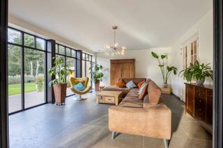 Deze prachtig afgewerkte villa bevindt zich op een bijzonder rustige en residentiële locatie in een jonge doodlopende verkaveling, omringd door groen. Je woont hier in alle privacy en comfort, met tegelijk een vlotte verbinding naar Mol, Balen, omliggende gehuchten en lokale winkels.<br /><br />Via de inkomhal, met gastentoilet en ingebouwde vestiaireruimte, kom je zowel in de woonkamer als in de leefkeuken. De woonkamer geniet dankzij de grote ramen van veel natuurlijke lichtinval en heeft een mooi zicht op de groene tuin. De leefkeuken bestaat uit een kwalitatieve aanbouwkeuken die voorzien is van alle comfort, met granieten werkbladen, een Amerikaanse koelkast, diepvries, heteluchtoven, microgolfoven, stoomoven, inductiekookplaat met teppanyakiplaat en geïntegreerde afzuigkap, een vaatwasser (allen Miele) en veel kastruimte. De eethoek grenst aan het overdekte terras. Doordat de keuken tot in de nok is opengetrokken, geniet je hier van een aangenaam ruimtegevoel. De authentieke eiken balken zorgen voor karakter en gezelligheid. In de woning is tevens een Sonos-installatie geïntegreerd, wat zorgt voor een warme sfeer en een heel aangename beleving in het dagelijkse wooncomfort.<br /><br />Op de verdieping zijn er drie ruime slaapkamers, waarvan er twee beschikken over een eigen dressing en een aansluitende badkamer. De badkamer van de masterbedroom is uitgerust met een ligbad, douche, dubbele wastafel en toilet. De andere badkamer omvat een douche, enkelvoudige wastafel en toilet. Op deze verdieping bevindt zich ook de linnenkamer, voorzien van inbouwkasten en een handige uitgietbak. Een luik met uitschuiftrap geeft toegang tot de zolderverdieping, die perfect dienstdoet als extra stockageruimte en waar je, indien gewenst, nog een extra (slaap)kamer kan creëren.<br /><br />In de tuin bevindt zich een prachtig overdekt en deels afgesloten terras waar je geniet tot de laatste avondzon. Verder is er een beregeningsinstallatie, een maairobot, sfeervolle buitenverlichting en een houten tuinhuis. Wanneer de woning wordt gekocht op enkel het linker perceel, dient het tuinhuis te worden afgebroken omdat het zich midden op de perceelsgrens bevindt.<br /><br />Het rechter perceel (30m breed x 40m diep) is tevens een bouwgrond en zit bij in de prijs begrepen!<br /><br />De woning is volledig voorzien van vloerverwarming en vloerkoeling via een warmtepomp met diepteboring. De voorzieningen voor airco zijn voorbereid en weggewerkt, maar bleken voor de huidige eigenaars niet nodig. Een balansventilatiesysteem type D met bypass zorgt voortdurend voor verse, gefilterde lucht. <br /><br />De villa beschikt over een zeer ruime garage voor twee wagens, met extra opbergruimte. De grote dubbele deur maakt het makkelijk om ook grotere stukken binnen te brengen. Een deel van de technieken is hier ondergebracht, zoals de omvormer van de 41 zonnepanelen, de thuisbatterij van 29,5 kWh en de centrale van het alarmsysteem. Een deel van de woning is onderkelderd, de rest heeft een kruipkelder.<br /><br />Ben je op zoek naar een ruim ingedeelde en kwalitatief afgewerkte villa op een mooi perceel in een rustige groene omgeving? Dan is deze woning ongetwijfeld een bezoekje waard.