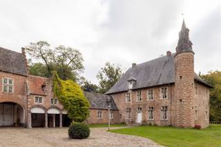 <p><span><span>Kasteelhoeve op uniek perceel in Tielen</span></span></p><p><span><span>In het groene landschap van de Kempen, vlak bij het recreatiedomein van De Hoge Rielen, bevindt zich het historische domein Tielenhof. Dit omgrachte kasteelgoed, waarvan de oorsprong teruggaat tot de 14de eeuw, ligt in het charmante dorp Tielen. Ondanks de rustige en landelijke setting geniet het domein van een vlotte bereikbaarheid: het treinstation van Tielen ligt op slechts enkele minuten wandelen, op ongeveer 800 meter afstand.</span></span></p><p><span><span>De geschiedenis van Tielenhof gaat eeuwen terug. Vermoedelijk liet Hendrik van Duffel rond 1350 op deze plek een kasteel optrekken dat lange tijd dienstdeed als residentie van de heren van Tielen. Doorheen de eeuwen wisselde het domein meermaals van eigenaar via huwelijken en erfenissen binnen verschillende adellijke families. Pas in 1958 werd het voor het eerst verkocht buiten deze kringen. Het kasteel kende meerdere verbouwingen: een ingrijpende aanpassing in 1830 transformeerde het tot een zomerresidentie, waarbij een deel van het oorspronkelijke middeleeuwse karakter verdween. Tijdens een restauratiecampagne in de jaren 1970 werden opnieuw historische elementen uit de 16de en 17de eeuw in ere hersteld, waaronder kruiskozijnen en de kenmerkende traptoren.</span></span></p><p><span><span>Vandaag vormt Tielenhof een karaktervol L-vormig geheel, opgebouwd in traditionele baksteen en zandsteen. De hoofdvleugel telt twee bouwlagen en wordt afgedekt met een steil schilddak. Het geheel wordt aangevuld met verschillende bijgebouwen, waaronder een barok koetshuis uit 1686 en een poortgebouw met houten ophaalbrug. De toegang tot het domein verloopt via de indrukwekkende Kasteeldreef: een circa 230 meter lange, gekasseide beukendreef die leidt naar het omgrachte terrein van ongeveer 1,7 hectare. Kastelen van dit type zijn uitzonderlijk in de Kempense regio en maken van Tielenhof een bijzonder stukje erfgoed.</span></span></p><p><span><span>De ligging midden in een natuurgebied maakt het domein uniek, maar vraagt tegelijk om een doordachte invulling. De bestemming blijft hoofdzakelijk residentieel, al zijn er diverse interessante mogelijkheden denkbaar: bijvoorbeeld een woonproject met mantelzorg of kangoeroewonen, het combineren van wonen met een kleinschalige horecazaak zoals een bistro of restaurant, of een cohousingconcept waarbij het karakter van één huishouden behouden blijft. Voor wie op zoek is naar een uitzonderlijke woonplek met geschiedenis, natuur en potentieel, biedt Tielenhof een zeldzame kans.</span></span></p><p> </p><p><span><span>Interesse? Bel ons nu voor het inplannen van een afspraak op 0489/89.49.74.</span></span></p>