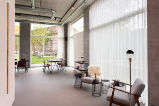 <p>Deze veelzijdige ruimte van ca 147 m² werd in 2019 top-notch afgewerkt en is gelegen op een werkelijke toplocatie pal in het Groen Kwartier. Deze site, een voormalig militair hospitaal, werd omgevormd tot een sublieme mix van wonen &amp; werken met een bestaande ziel in combinatie met veel groen en minimalistische nieuwbouw. Ondertussen één van de meest gegeerde wijken in Antwerpen, dankzij buren zoals August, PAKT en Broodnatie. <br /><br />Dankzij de grote raampartijen en hoge plafonds is er de hele dag door een prachtige natuurlijke lichtinval. Bovendien geen gebrek aan visibiliteit dankzij de hoekligging met open zicht op een groen aangelegd pleintje.</p>
<p>De polyvalente ruimte aan de voorzijde werd voorzien van een doorlopende gietvloer in terrazzolook, prachtig gedetailleerd en toch een neutrale basis.</p>
<p>De grote open ruimte - recht op recht - kan veelzijdig verder ingedeeld worden naar keuze.</p>
<p>Deze aparte, achteraan gelegen ruimtes kunnen ook polyvalent ingericht worden als aparte vergaderzaal, kantoorruimte, praktijkkamer, stockage etc en grenzen aan een privatieve patio van ca 46 m² met tweede (dienst)toegang en rechtstreekse lift naar de ondergrondse garage. In deze patio werd ook reeds een water- en elektriciteitsaansluiting voorzien.</p>
<p>Tot slot werden 2 aparte sanitaire ruimtes voorzien aan de inkom. Werkelijk een staaltje pure luxe met als eyecatcher een marmer lavabomeubel naar een eigen ontwerp van de eigenares.</p>
<p>Thans vergund als commerciële ruimte. Dankzij de polyvalente indeling leent deze handelsruimte zich echter ook ideaal als (medische) praktijk, kantoor, kunstgalerij, showroom etc. <br /><br />Een ruime autostaanplaats in de ondergrondse garage kan worden aangekocht aan 40.000 Euro, exclusief registratiebelasting.</p>