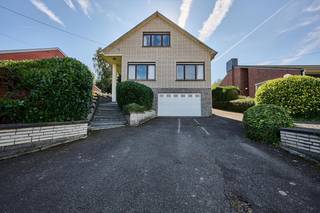 In een rustige, residentiële straat met een prachtig uitzicht op weiden en velden bevindt zich deze charmante, klassiek gebouwde villa op een perceel van meer dan 7 are 08 ca. Opgetrokken in 1976 met duurzame materialen en door de jaren heen zorgvuldig onderhouden, biedt deze woning een bewoonbare oppervlakte van ruim 284 m².<br />De gelijkvloerse verdieping verwelkomt u met een royale inkomhal met gastentoilet en vestiaire, gevolgd door een lichtrijke leefruimte met salon en eetplaats. Aansluitend bevindt zich een volledig ingerichte keuken, allemaal met uitzicht op de mooie, groene tuin in alle rust en privacy. Op hetzelfde niveau vindt u tevens twee ruime slaapkamers en een badkamer. De eerste verdieping, bereikbaar via een uitschuifbare trap, werd ingericht met twee bijkomende slaapkamers. De deels ondergrondse verdieping biedt een garage met automatische poort en verschillende praktische berg- en hobbyruimtes. Dankzij de rustige ligging en de uitstekende verbindingen in de buurt van scholen en winkels, geniet u hier van het beste van twee werelden: volledige rust met alle comfort binnen handbereik.<br />Voor meer informatie of een bezoek ter plaatse kan u terecht op 02/569 99 99.